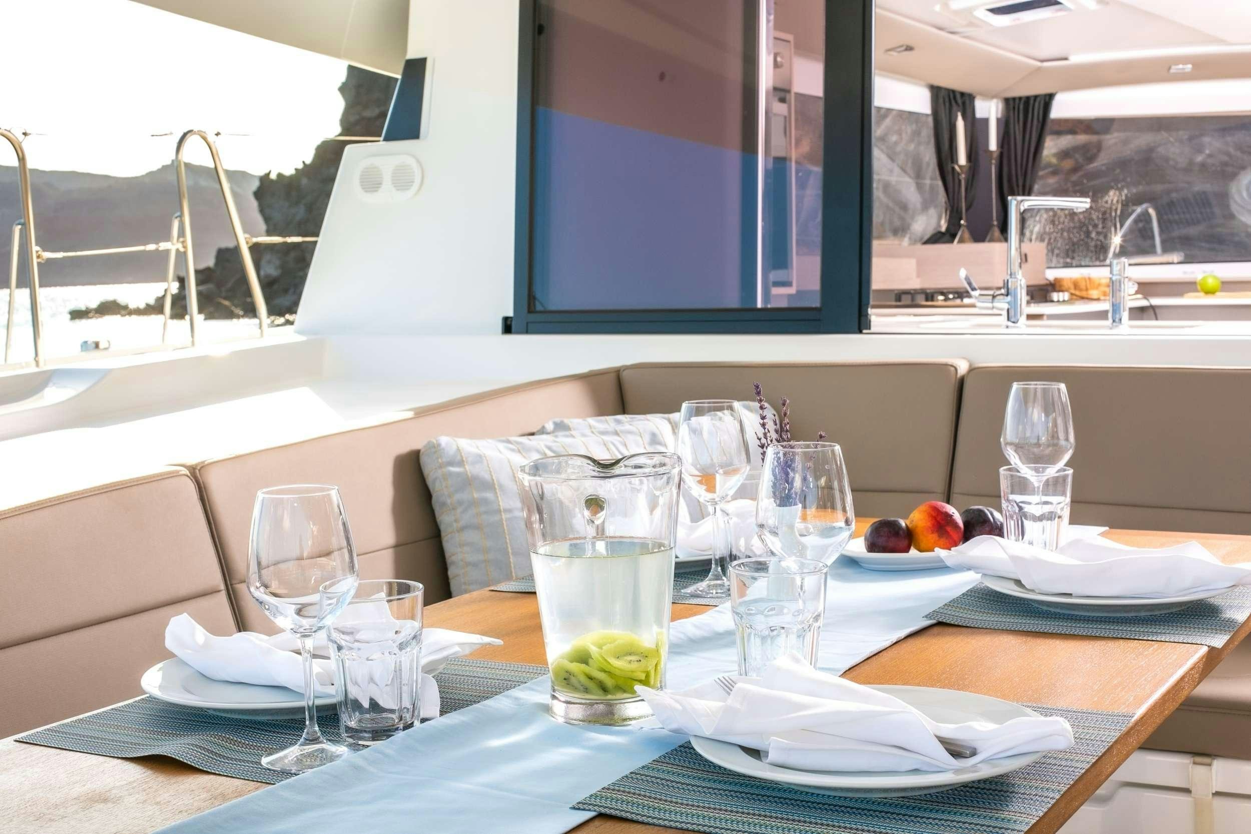 a table with plates and glasses aboard PAROS Yacht for Charter