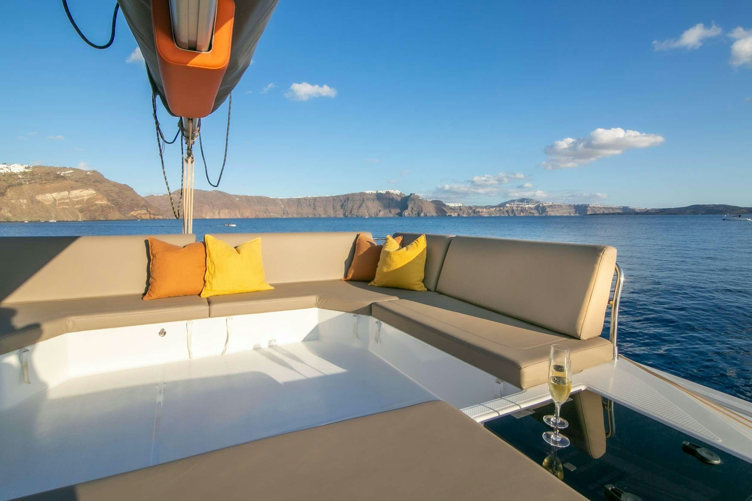 a boat on the water with Santorini in the background aboard PAROS Yacht for Charter