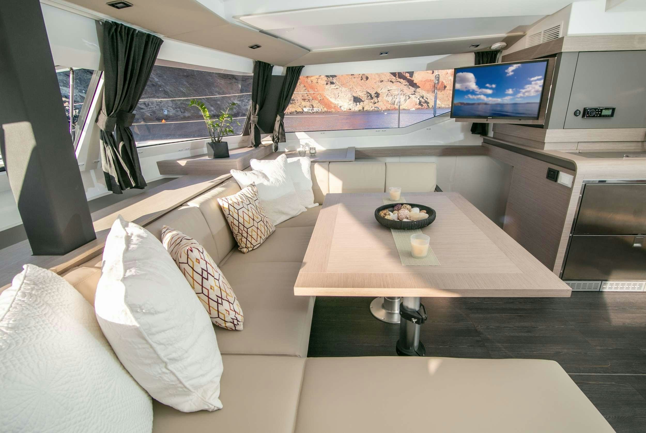 a room with a table and couches aboard PAROS Yacht for Charter