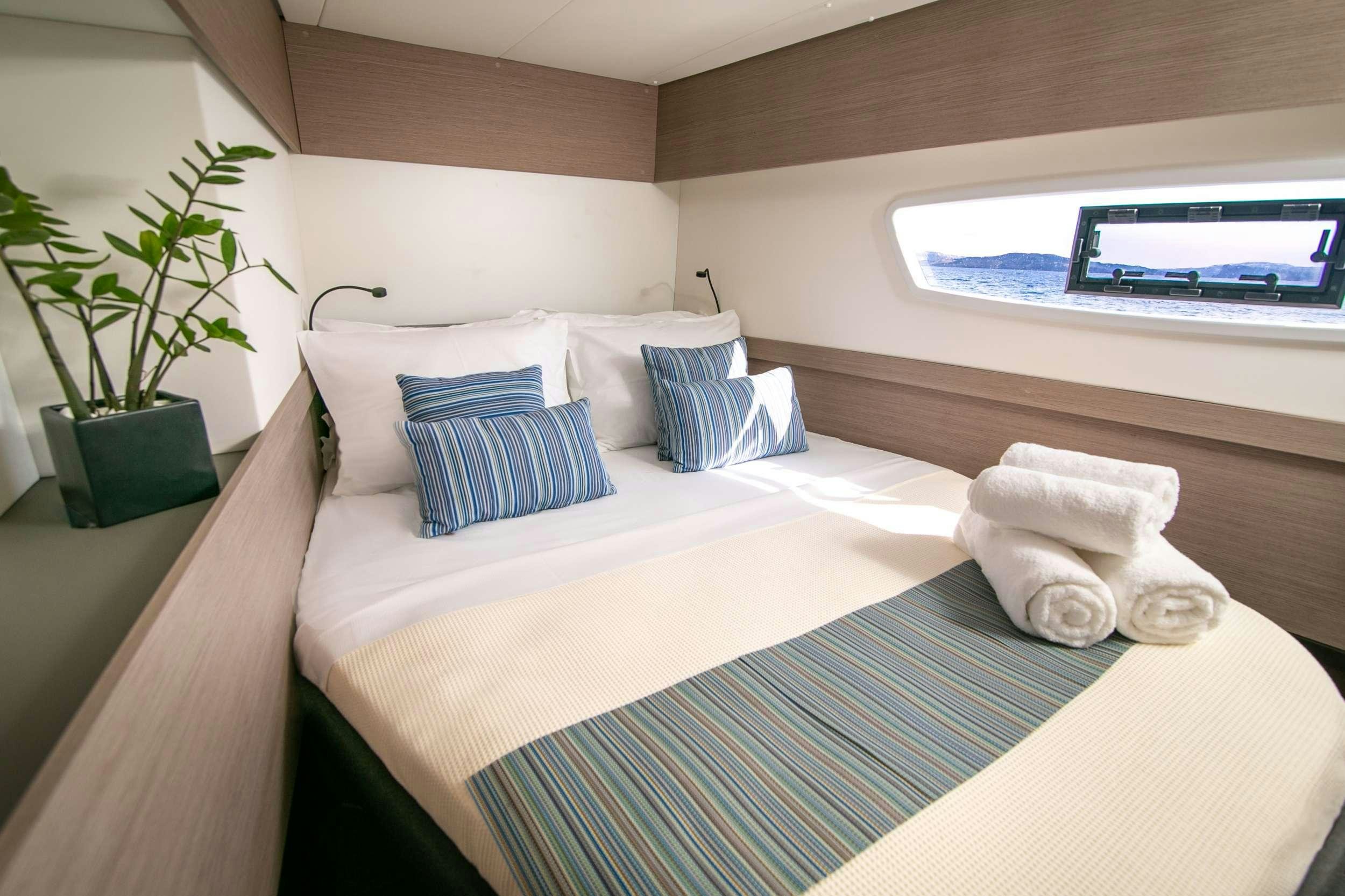 a bed with pillows and a plant aboard PAROS Yacht for Charter