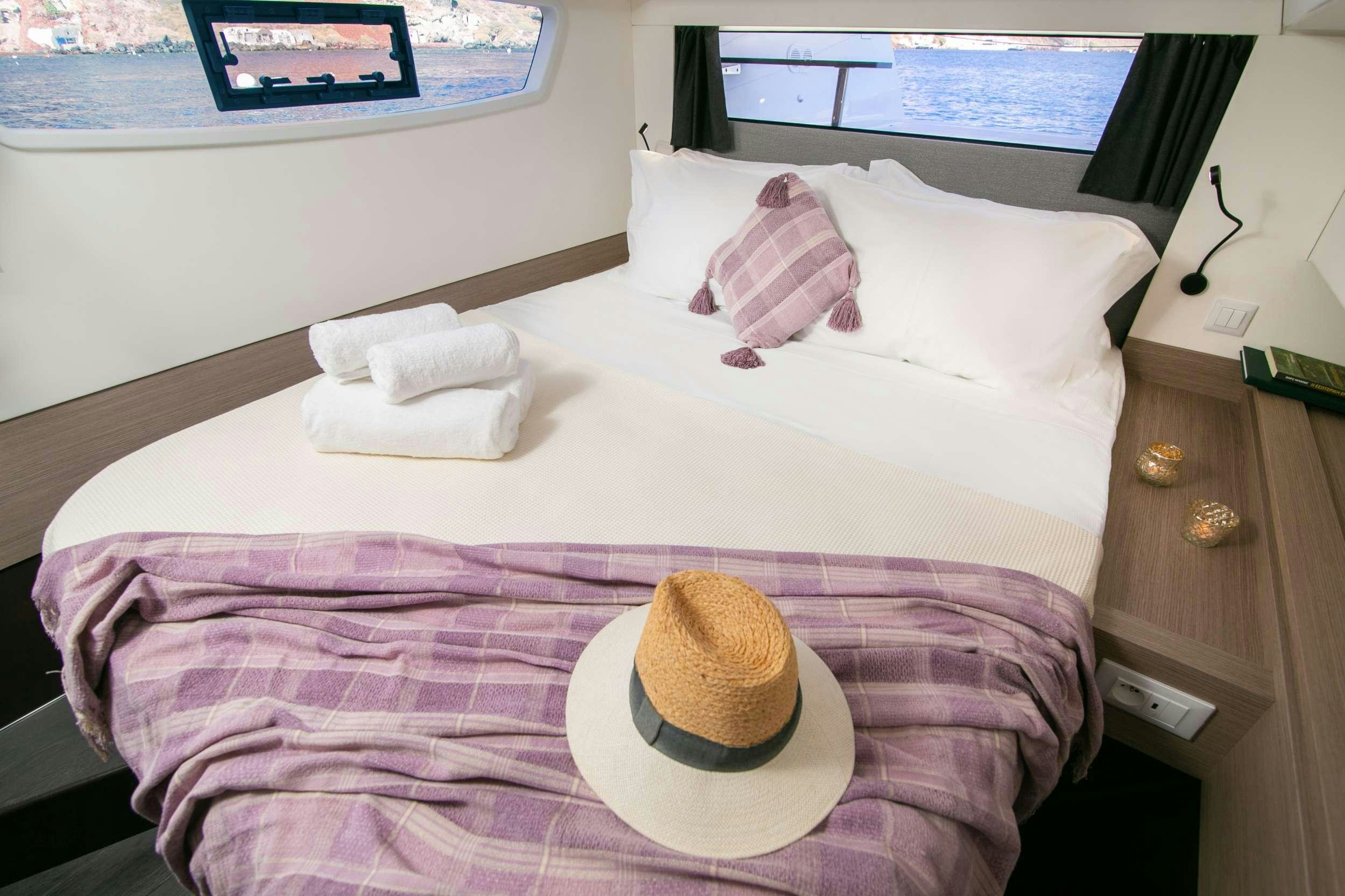 a bed with a hat on it aboard PAROS Yacht for Charter