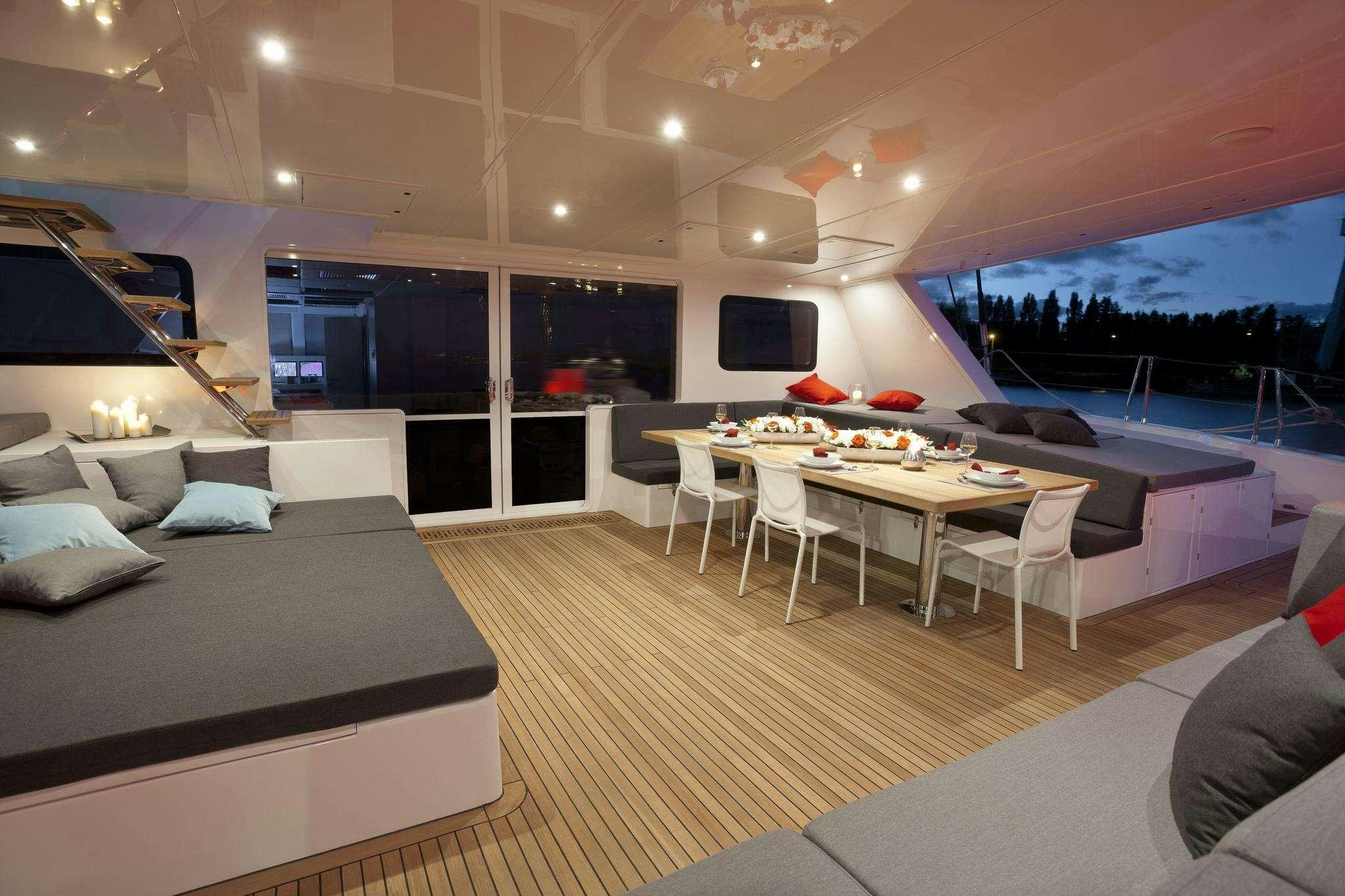 a room with a bed and a table and chairs aboard LEVANTE Yacht for Charter