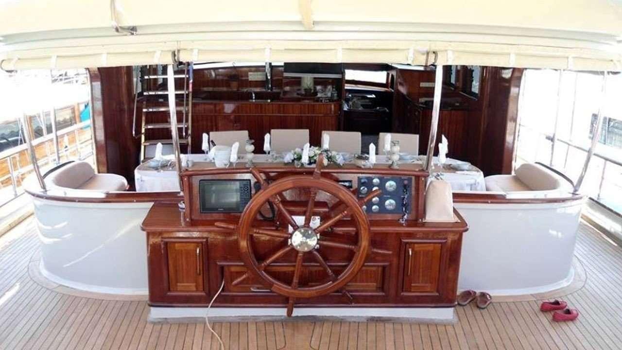 a room with a wood desk and a large wheel aboard M/S E.ARDA DENIZ Yacht for Charter