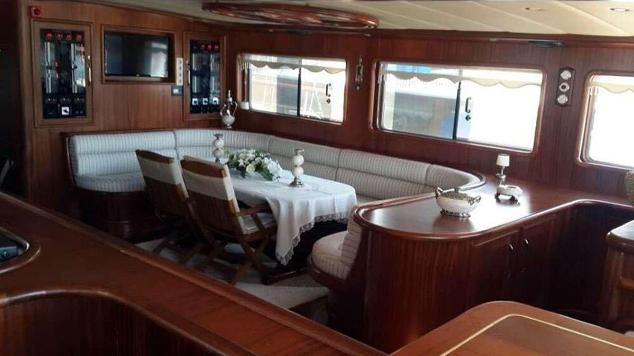 a room with a table chairs and a window aboard M/S E.ARDA DENIZ Yacht for Charter