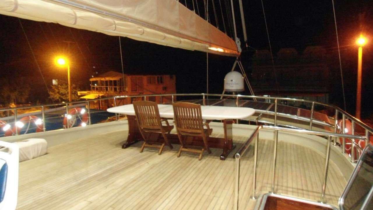 a deck with tables and chairs aboard M/S E.ARDA DENIZ Yacht for Charter
