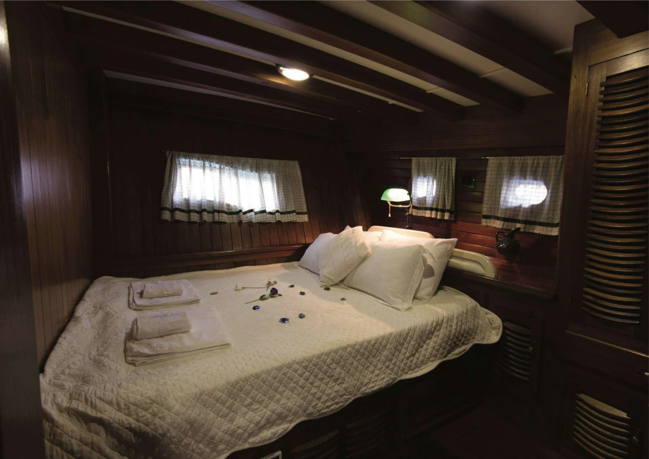 a bed with a white sheet aboard SERENAD Yacht for Charter