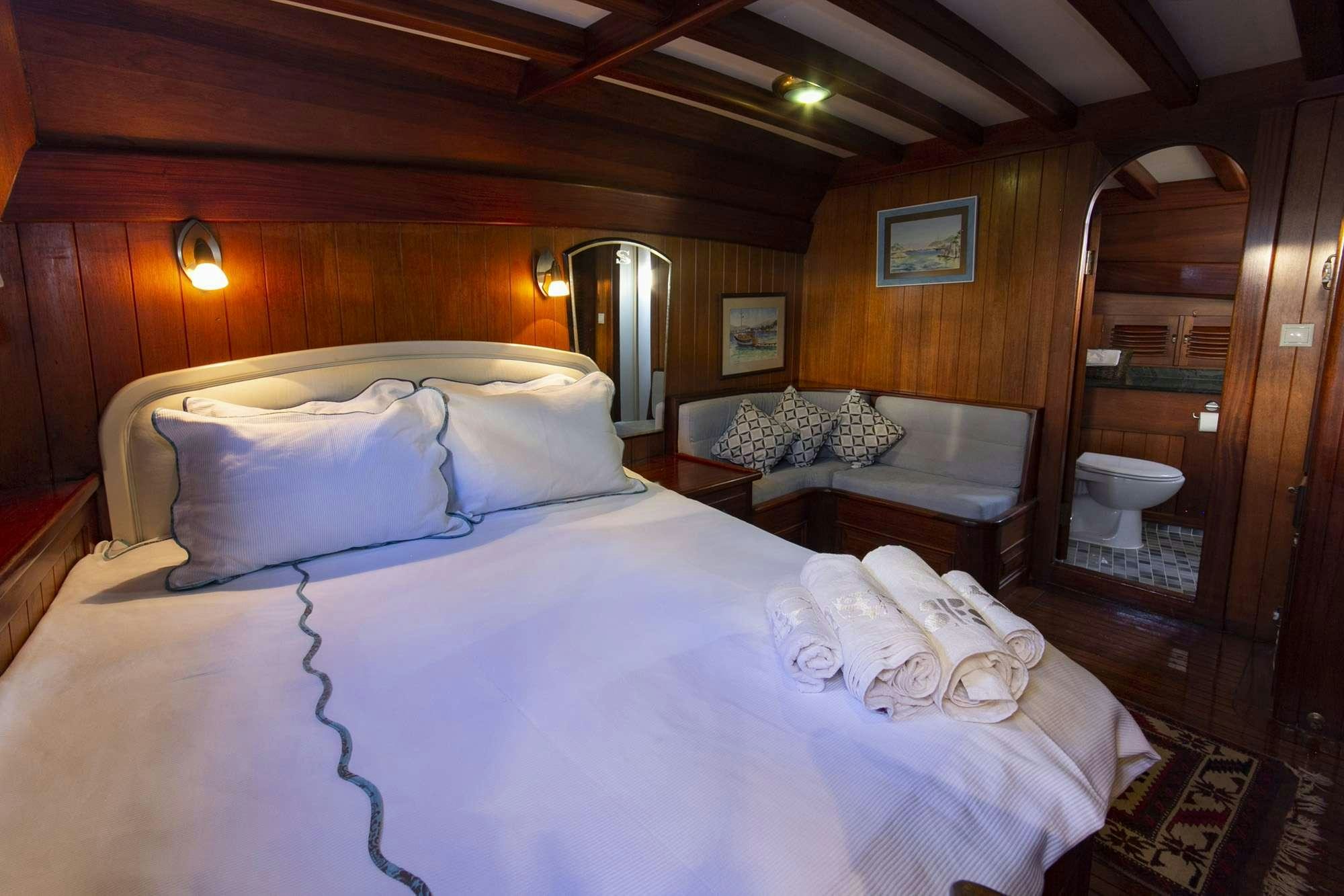 a bedroom with a bed and a mirror aboard SERENAD Yacht for Charter