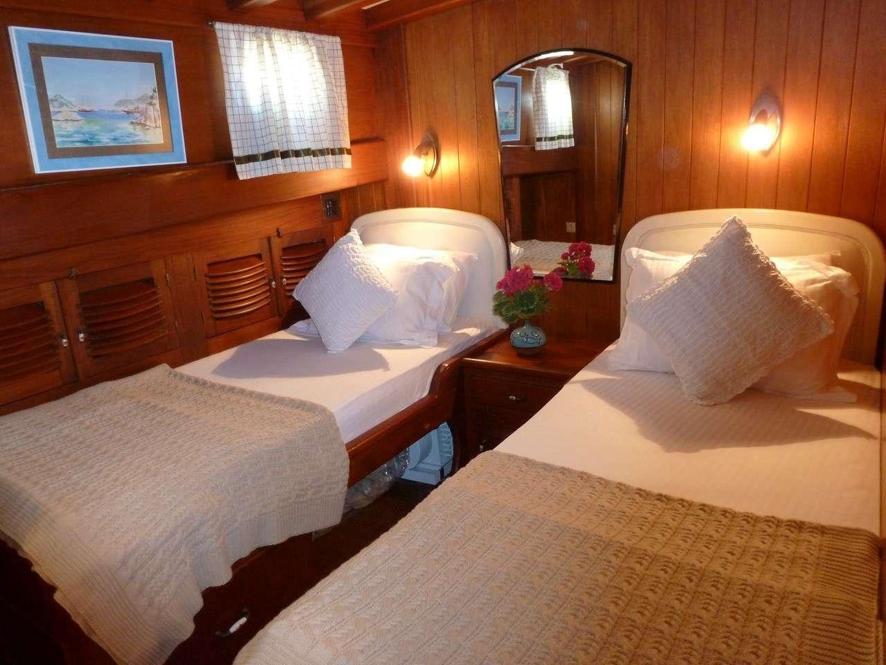 a room with beds and a mirror aboard SERENAD Yacht for Charter