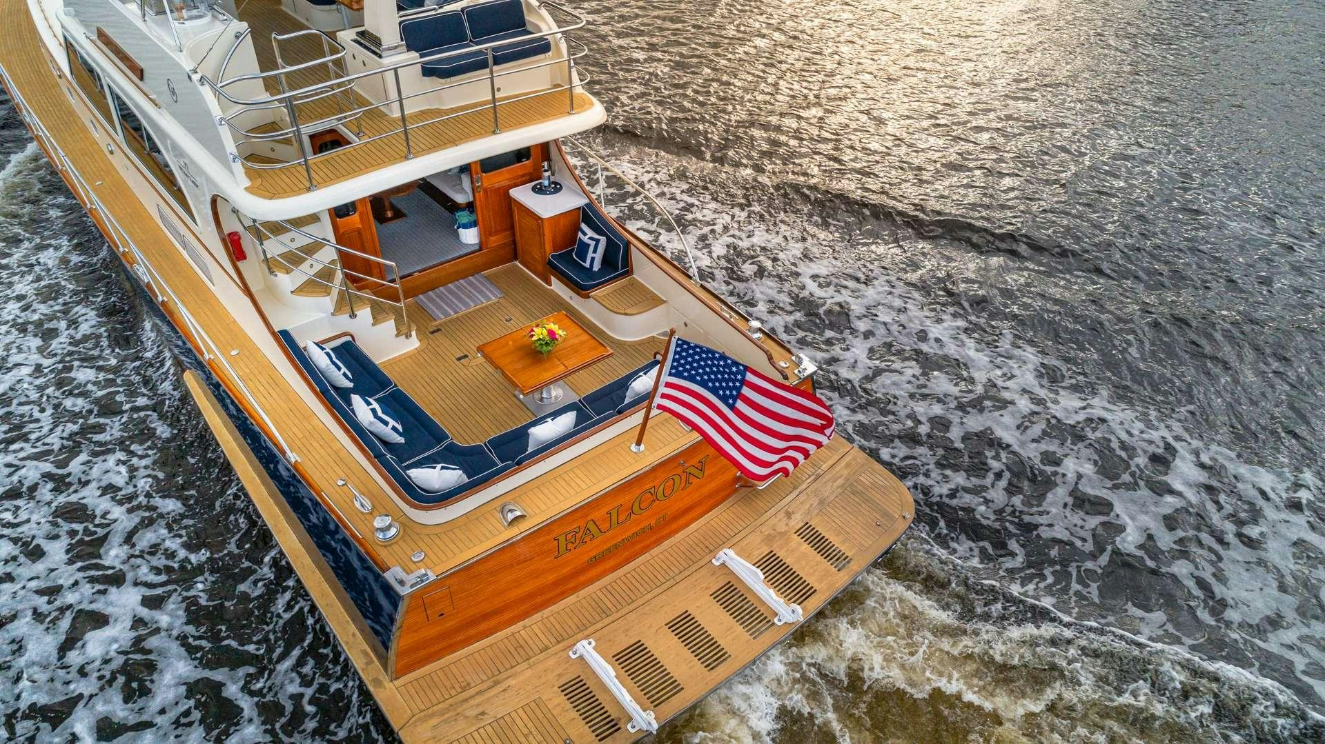 a boat with a flag on the front aboard FALCON Yacht for Charter