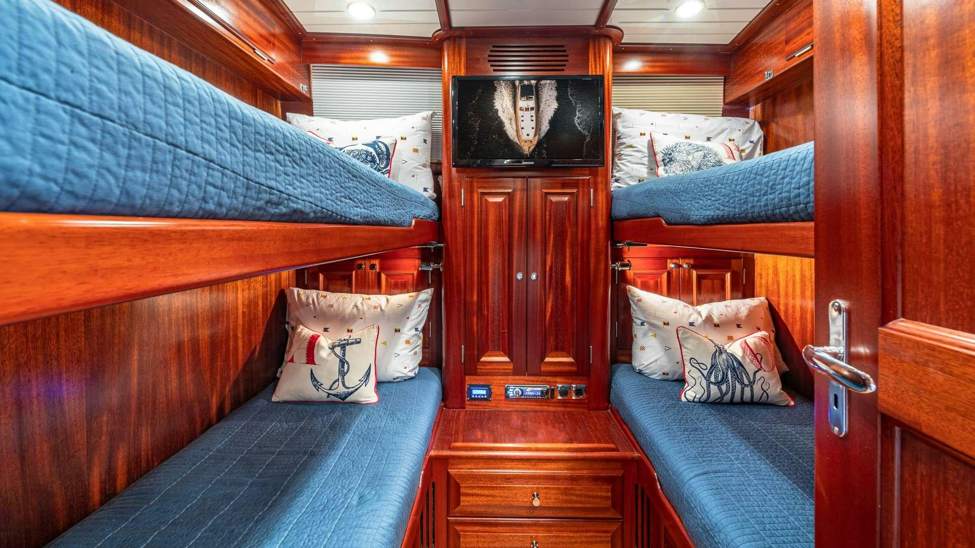 a room with a bed and a dresser aboard FALCON Yacht for Charter