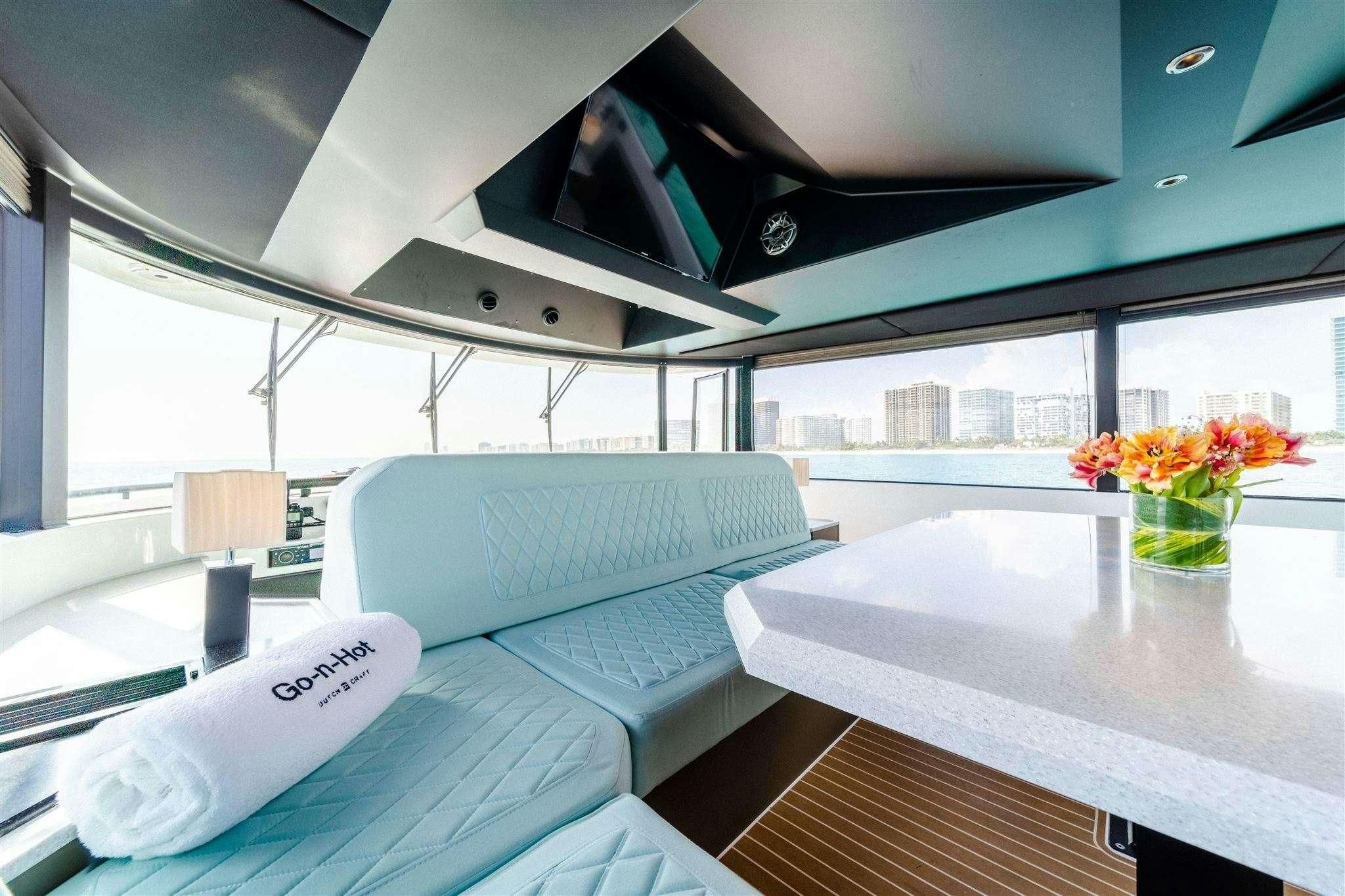 a room with a table and chairs aboard GO N HOT Yacht for Charter
