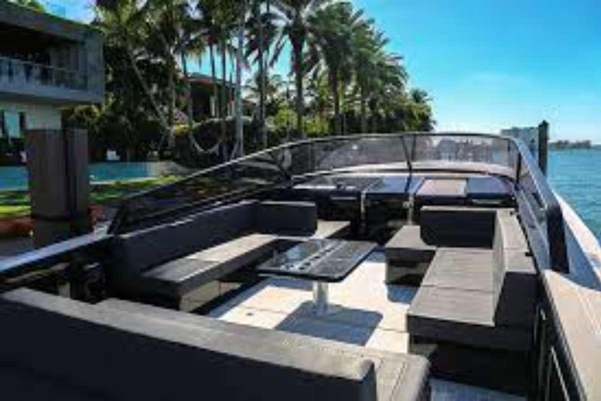 a pool with a deck and a building and trees in the background aboard BIG BANG Yacht for Charter