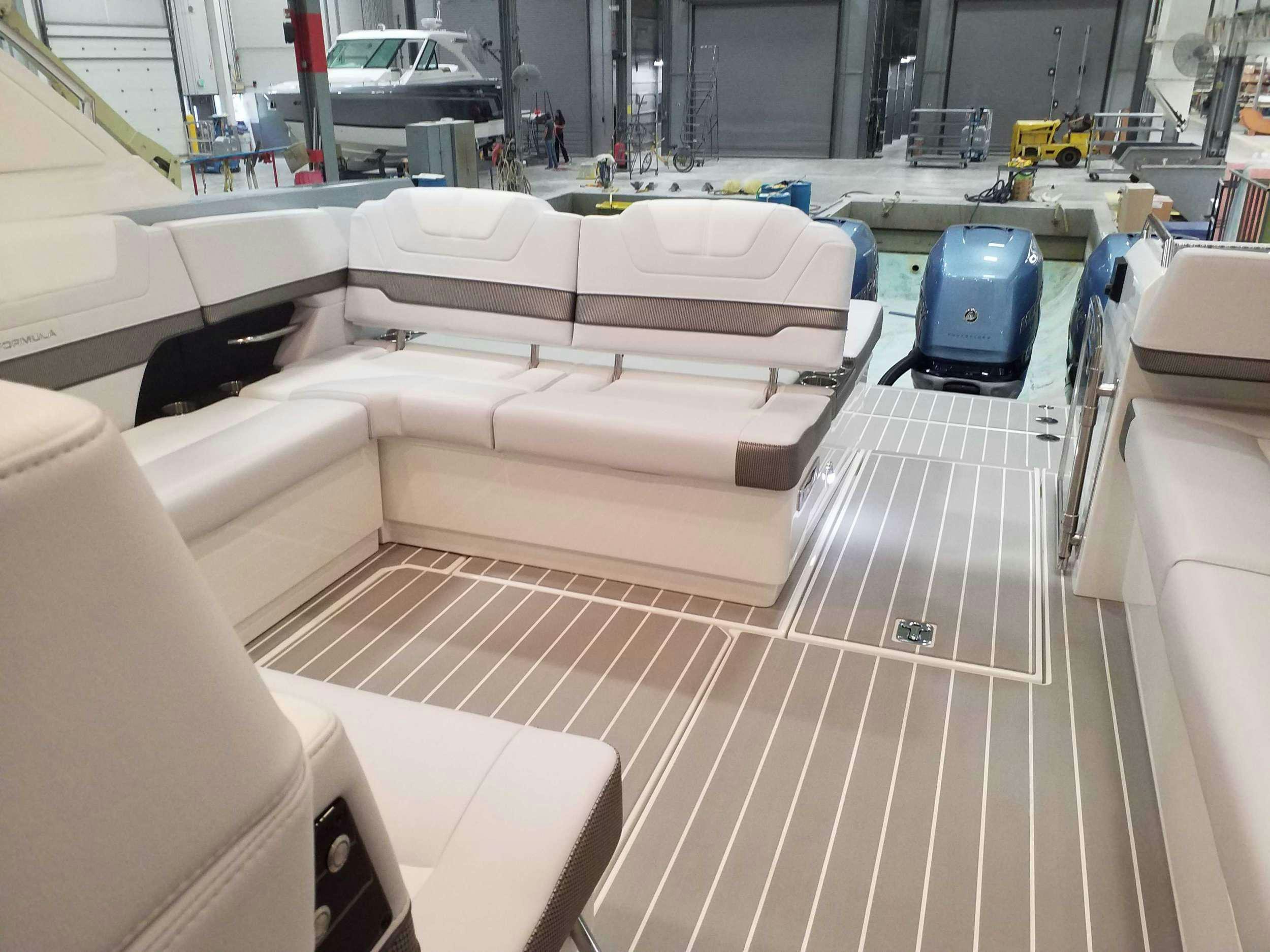 a room with a row of white couches and a blue car aboard Life Is Good Yacht for Charter