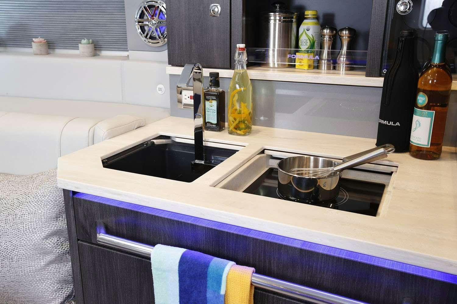 a kitchen sink with a dishwasher and bottles on the counter aboard Life Is Good Yacht for Charter