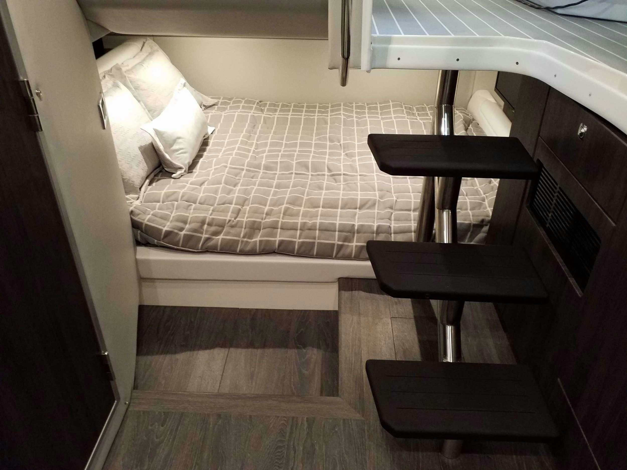 a chair next to a bed aboard Life Is Good Yacht for Charter
