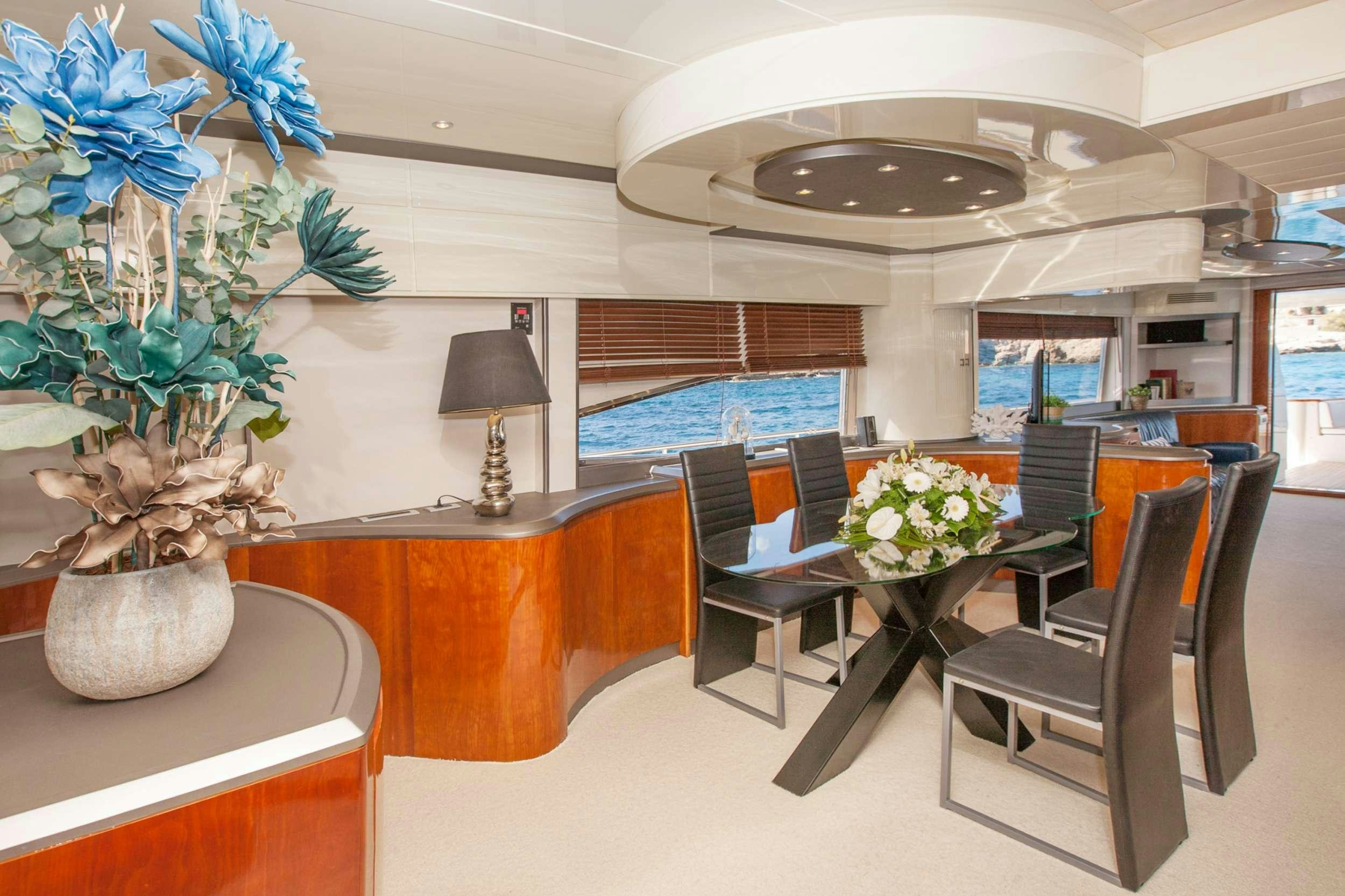 a room with a table chairs and flowers in it aboard WHITE FANG Yacht for Charter