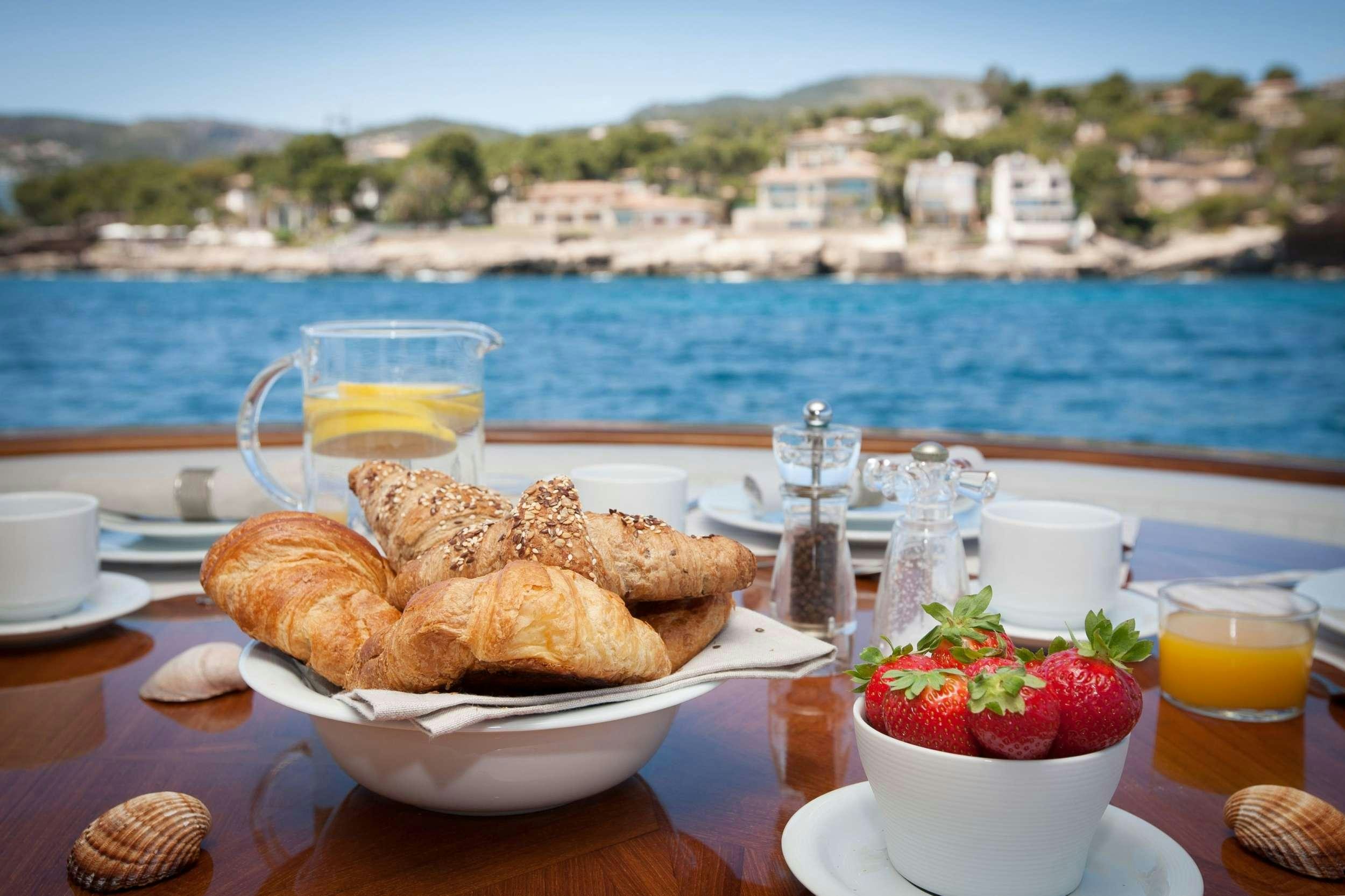 a table with food and drinks on it aboard WHITE FANG Yacht for Charter