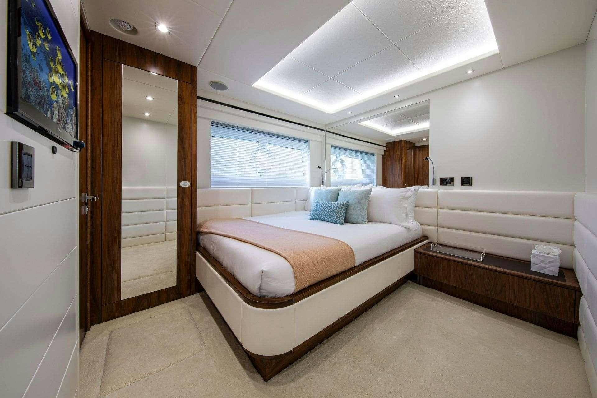 a bedroom with a bed and a desk aboard RUSH X Yacht for Charter