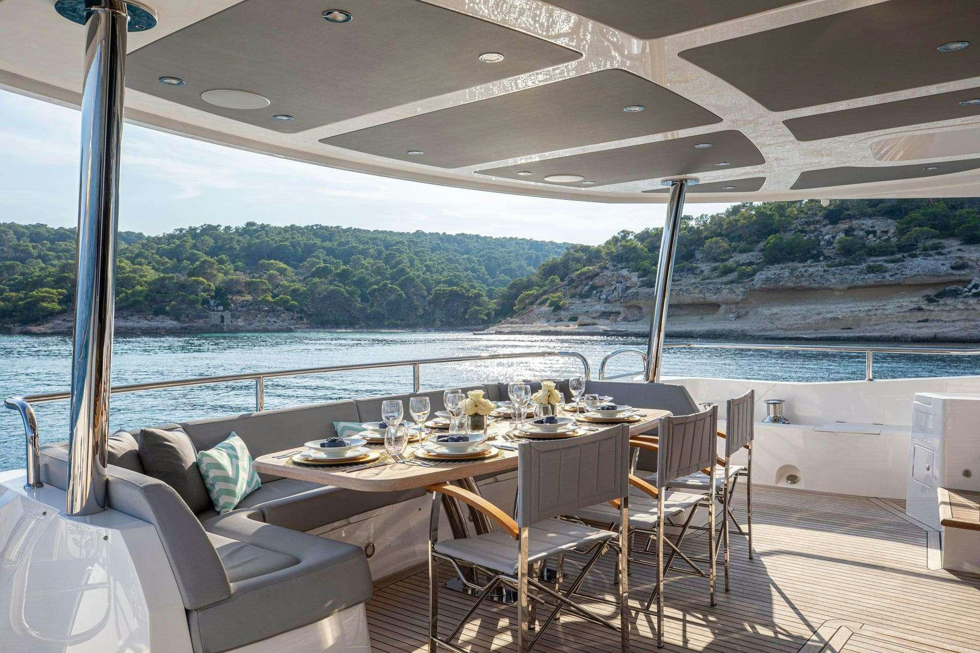 a table set for a meal on a deck overlooking a lake aboard RUSH X Yacht for Charter