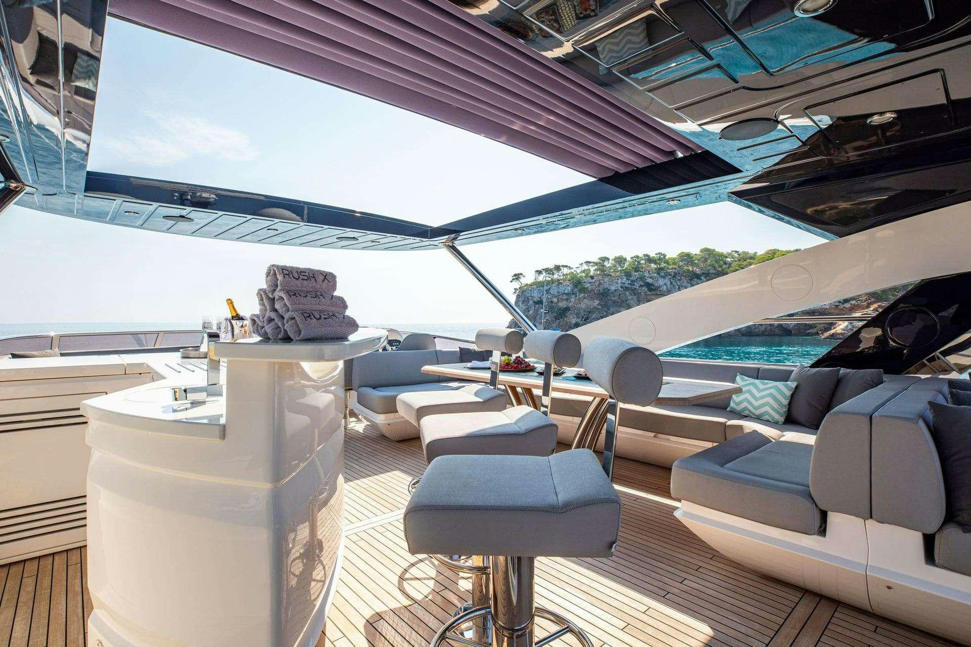 a boat with a large white lounge chair and a large white table with a large white table and aboard RUSH X Yacht for Charter