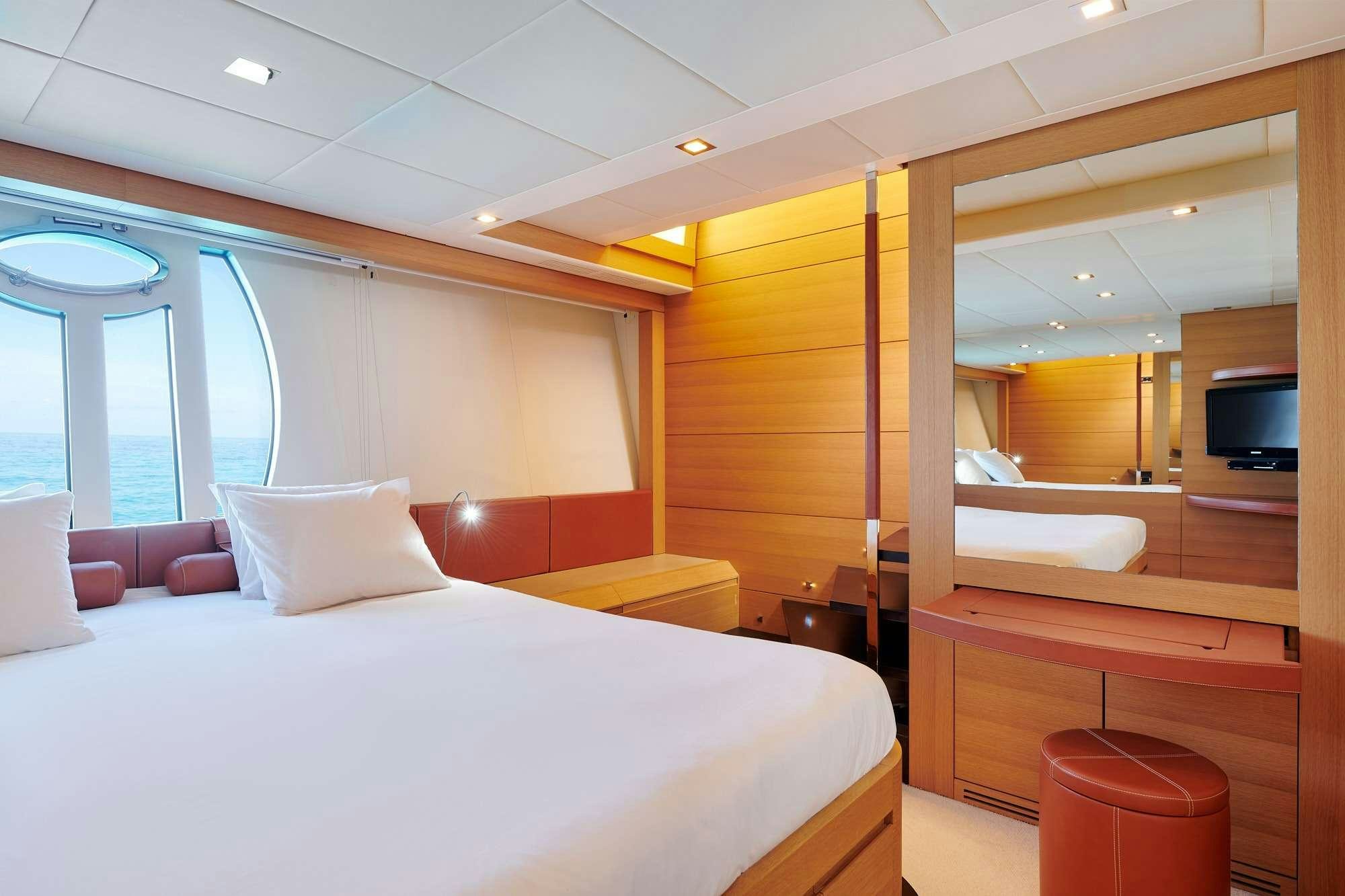 a room with a bed and a television aboard HALLEY Yacht for Charter