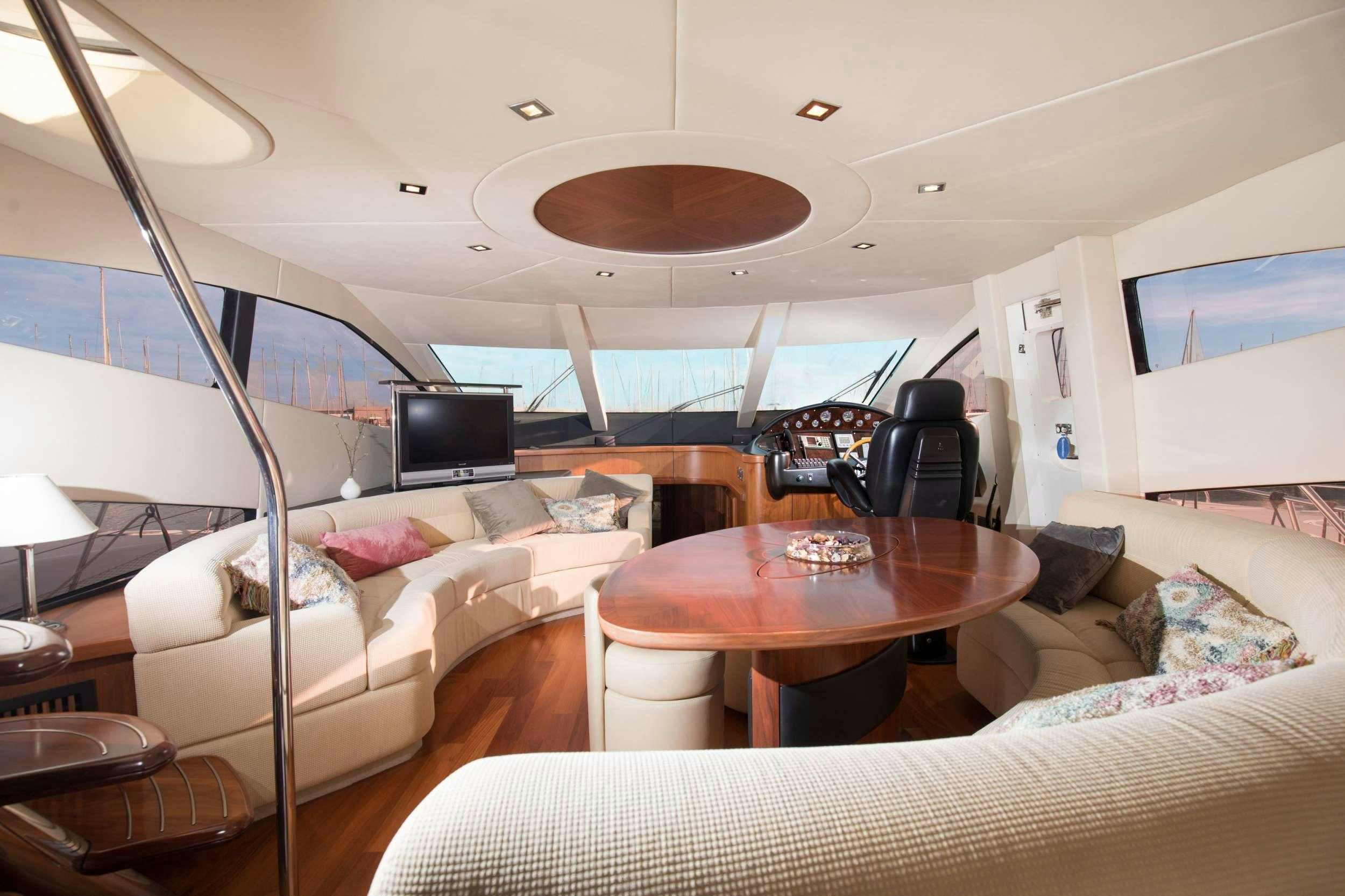 a living room with a large television and a table aboard MEDITERRANI IV Yacht for Charter