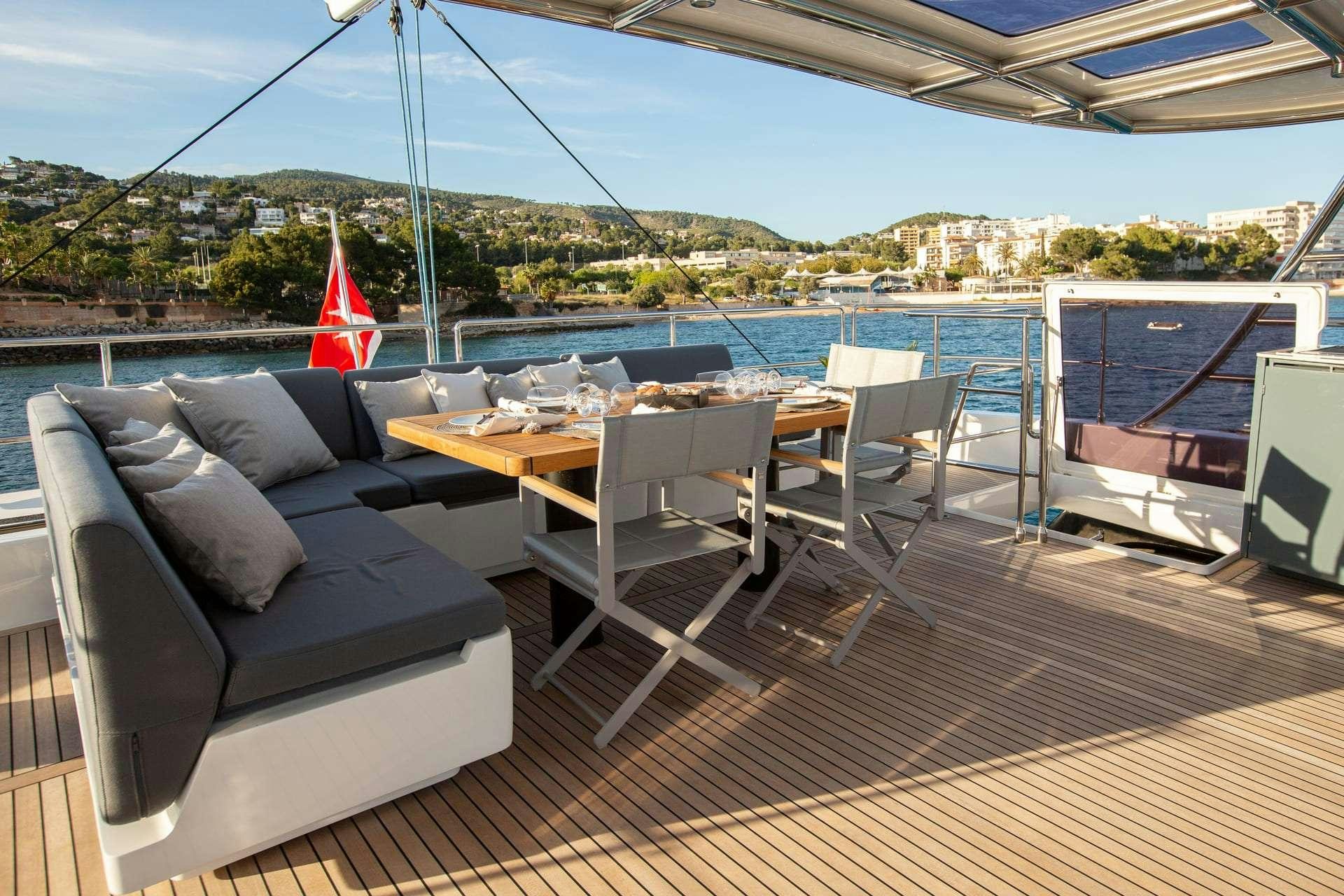 a deck with a table and chairs aboard SUNBREEZE Yacht for Charter