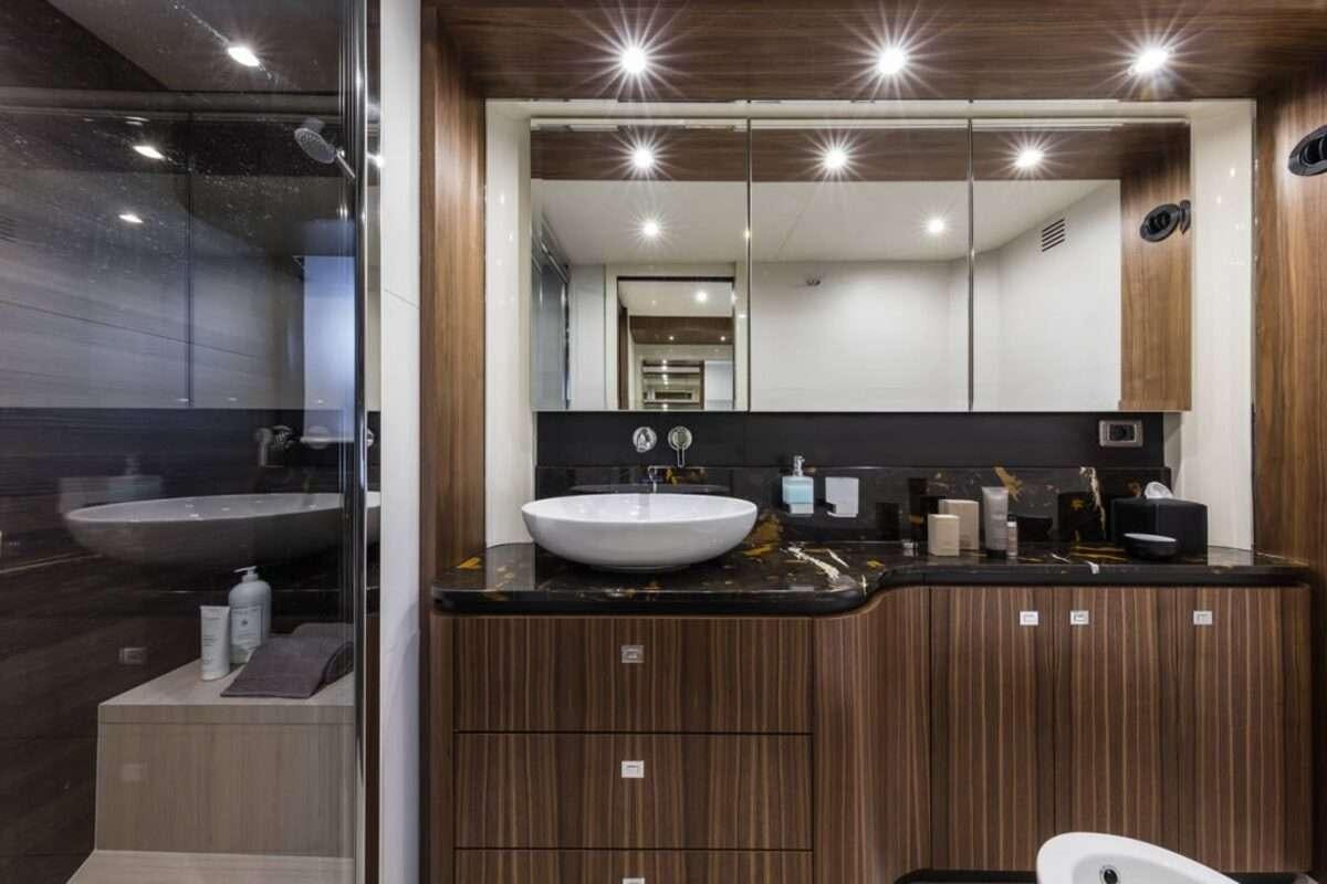 a bathroom with a sink and a large mirror aboard MAYBE5 Yacht for Charter