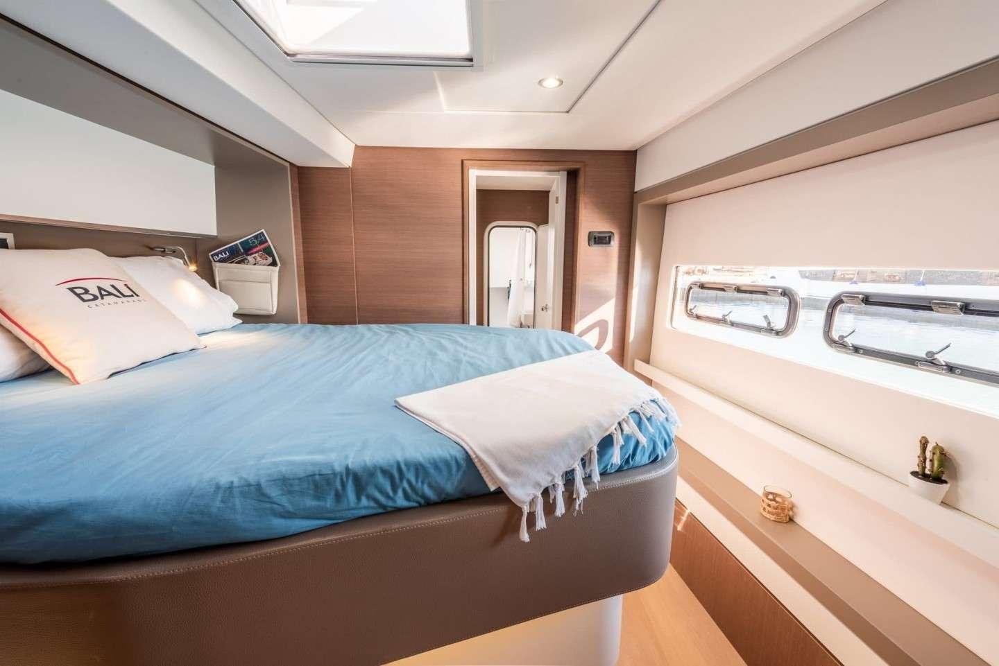 a bedroom with a bed and a sink aboard AMURA Yacht for Charter