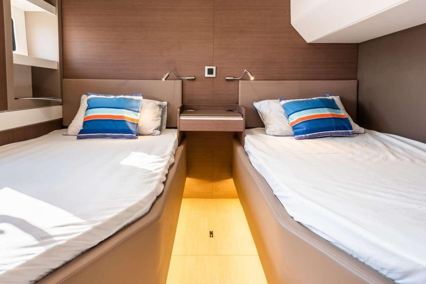 a couple of beds in a hotel room aboard AMURA Yacht for Charter