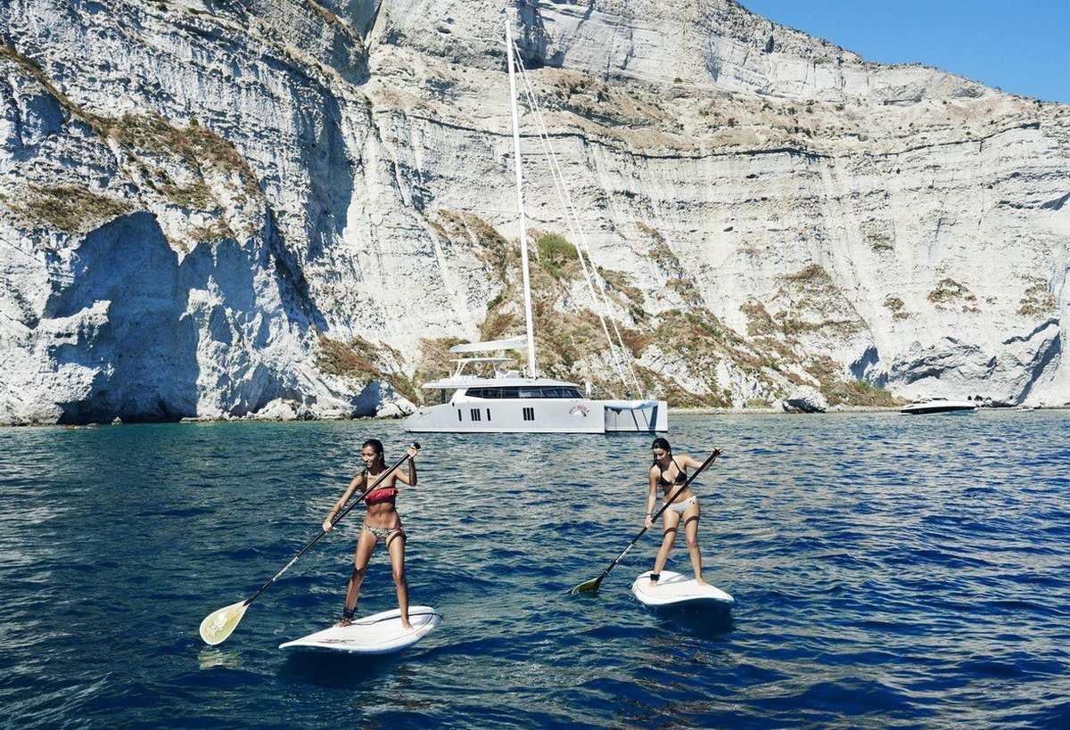 a couple of women paddle boarding aboard 19TH HOLE Yacht for Charter