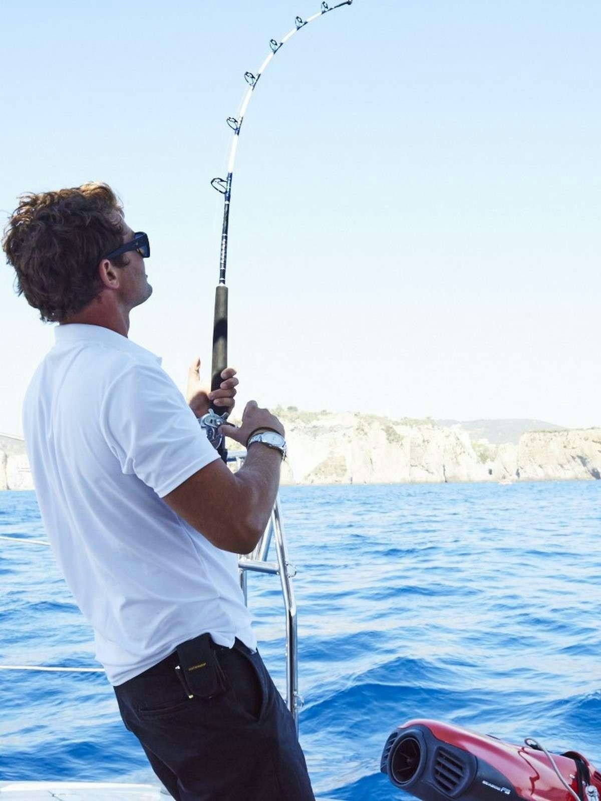 a man fishing on a boat aboard 19TH HOLE Yacht for Charter