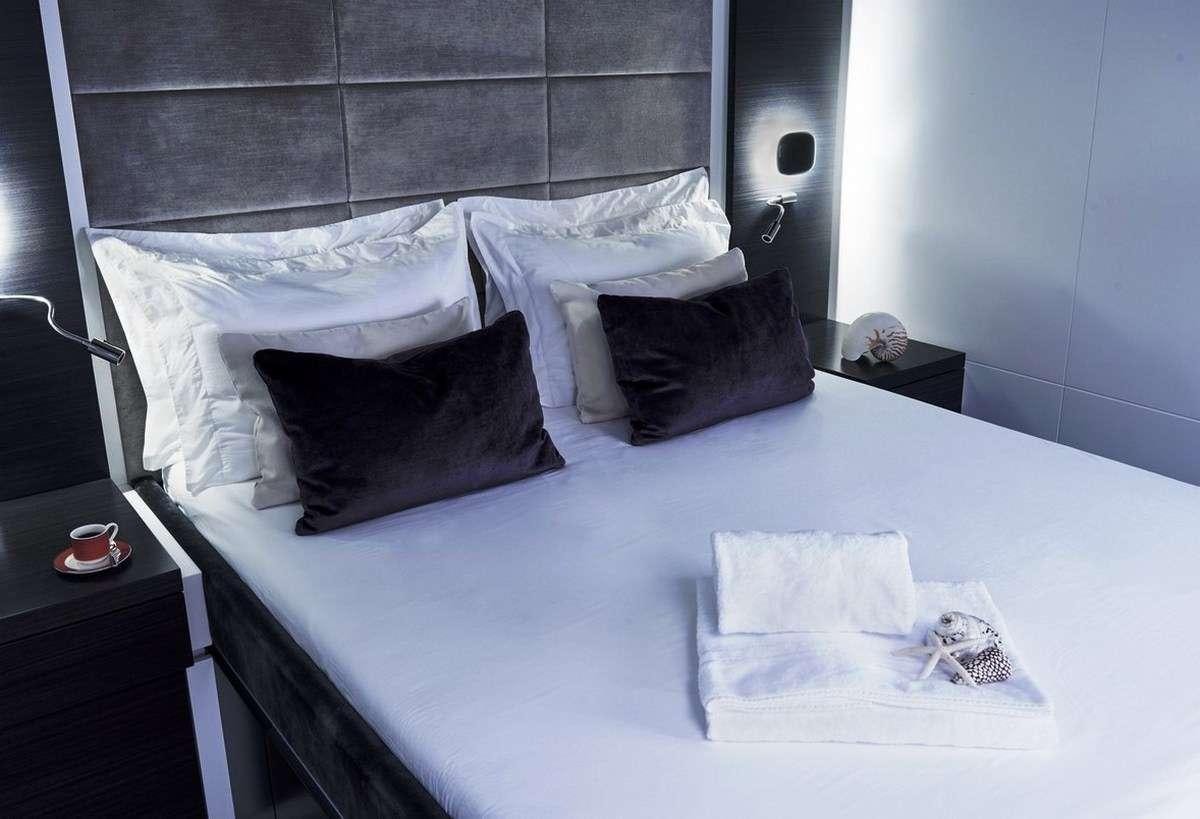 a bed with white sheets aboard 19TH HOLE Yacht for Charter