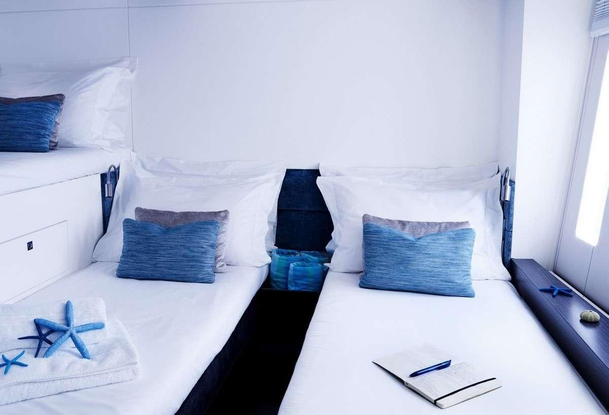 a bed with white sheets and pillows aboard 19TH HOLE Yacht for Charter