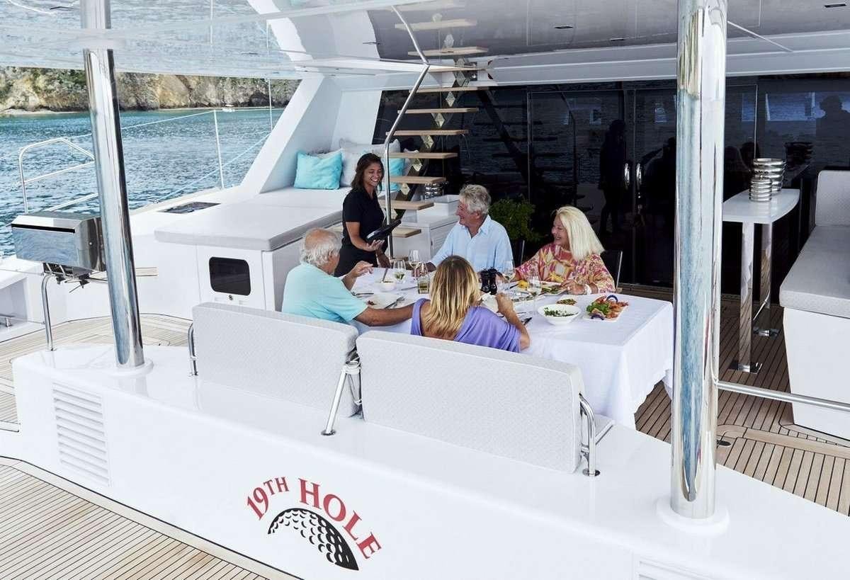 a group of people sitting around a table aboard 19TH HOLE Yacht for Charter