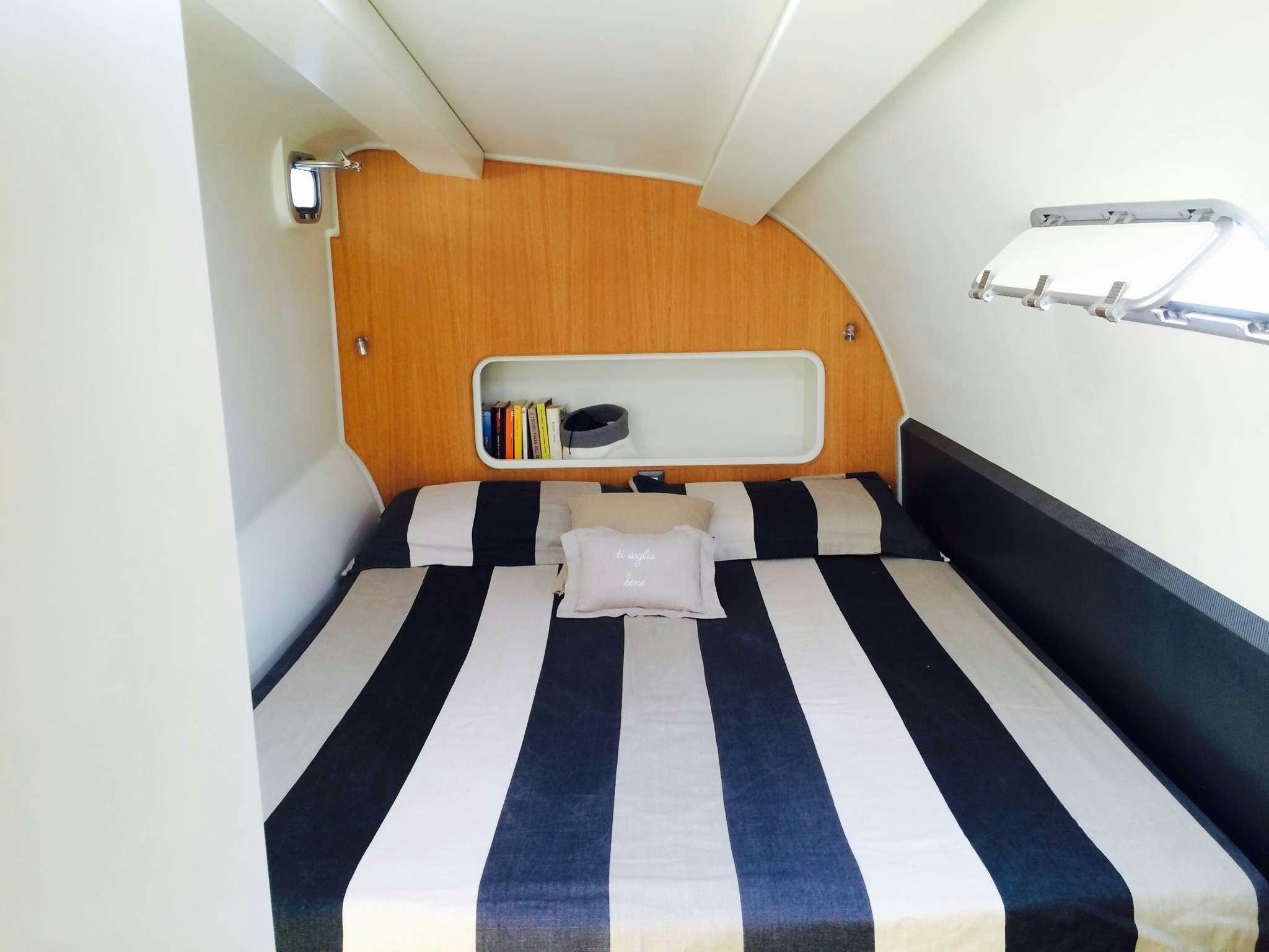 a room with a bed and a desk aboard Obi One Yacht for Charter