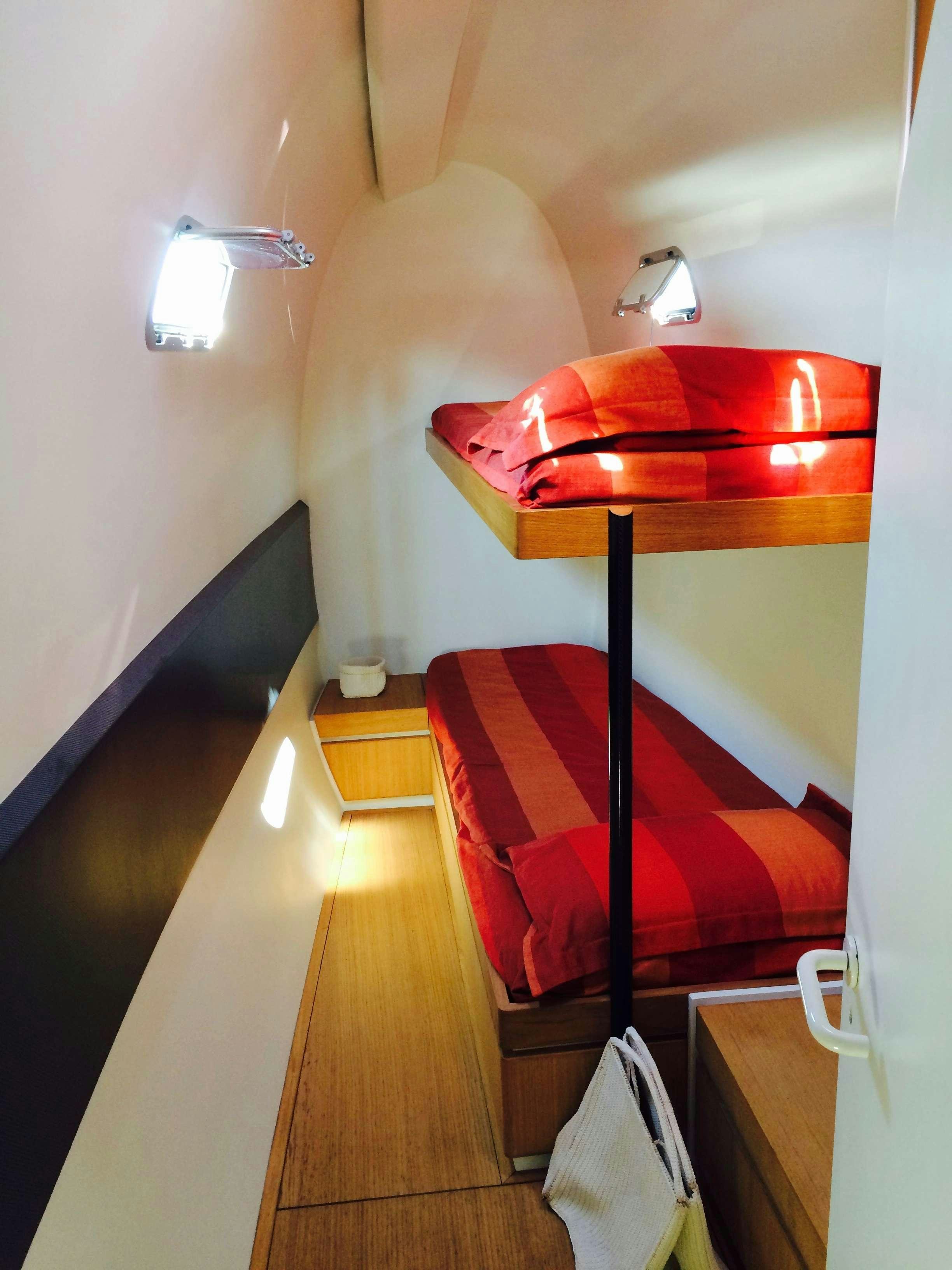 a bed with a red cover aboard Obi One Yacht for Charter