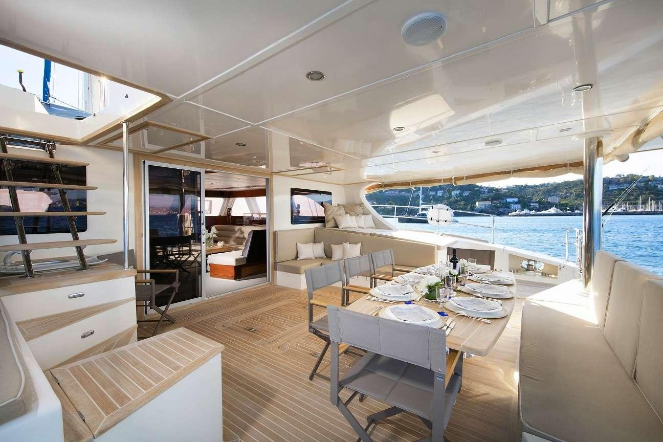 a room with a table chairs and a large window aboard Free Spirit Yacht for Charter