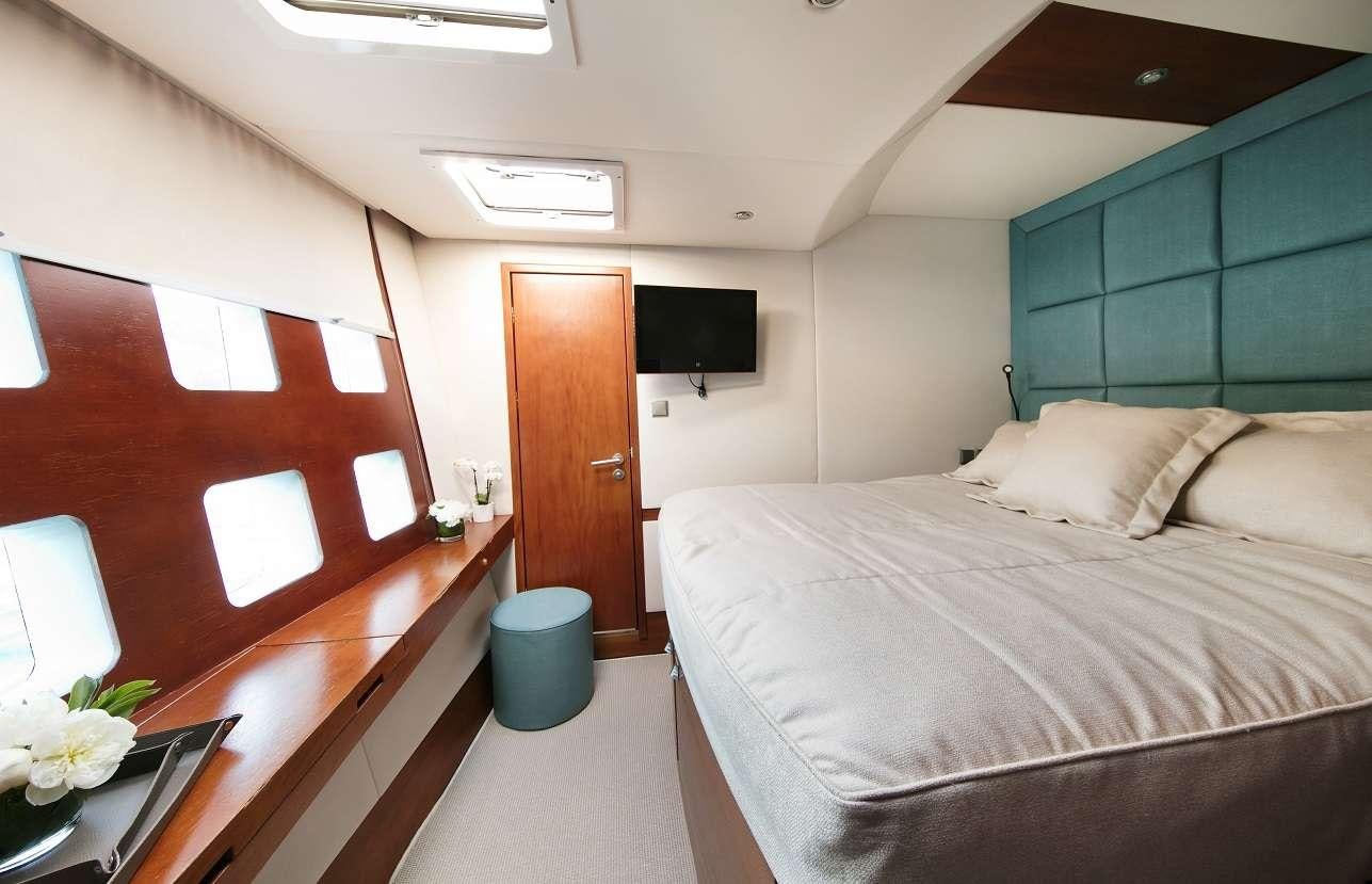 a room with a bed and a television aboard Free Spirit Yacht for Charter