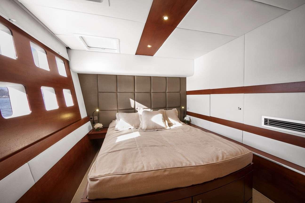a room with a bed and a window aboard Free Spirit Yacht for Charter