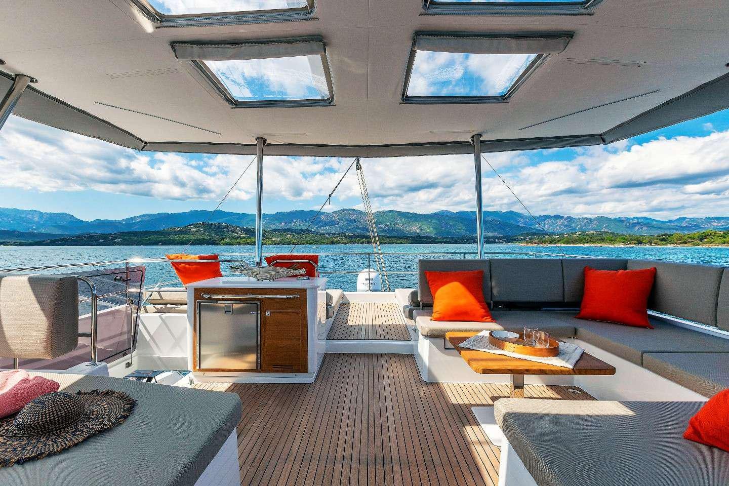 a room with a couch and a table and a view of the water aboard INSPIRANTE Yacht for Charter