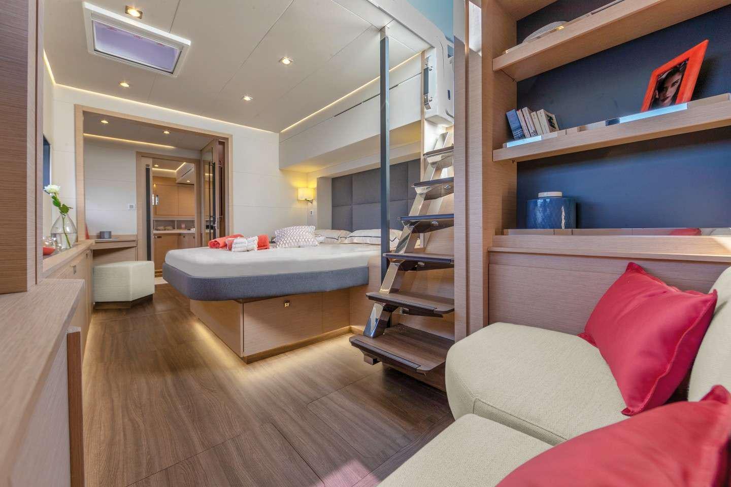 a bedroom with a bed and a bookcase aboard INSPIRANTE Yacht for Charter