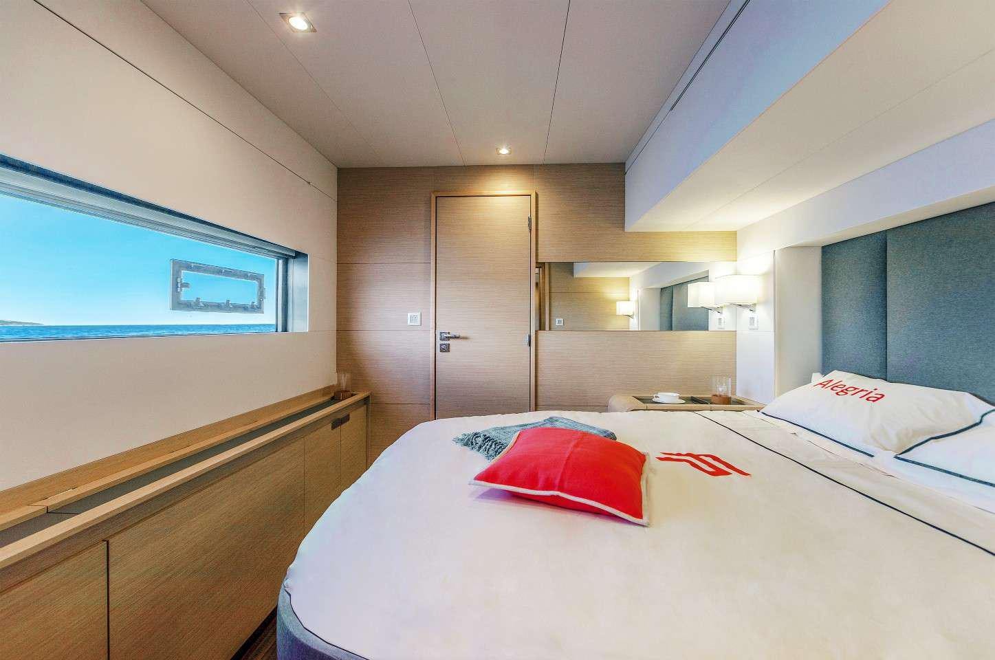 a room with a bed and a desk aboard INSPIRANTE Yacht for Charter