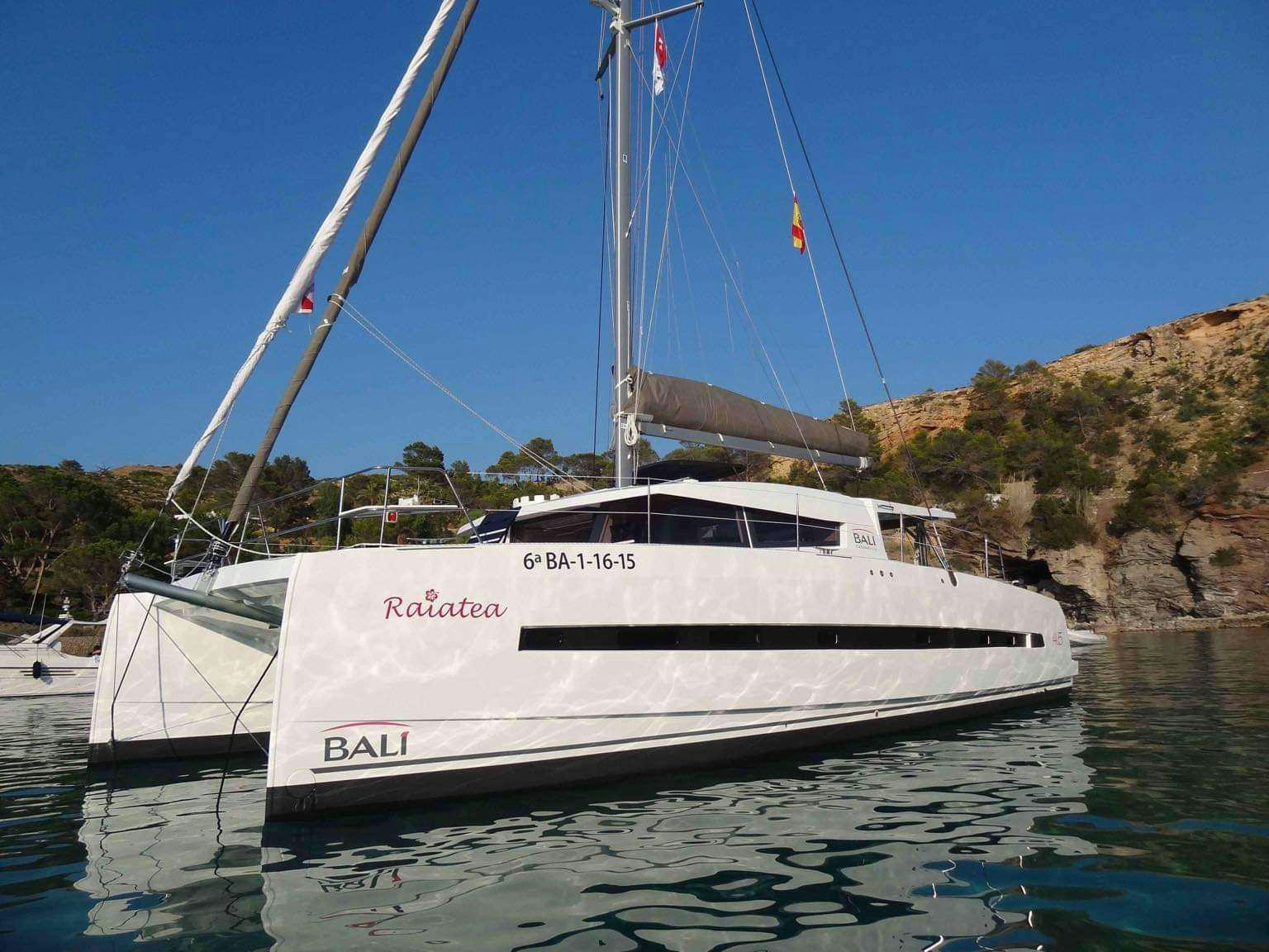 a white boat in a harbor aboard Raiatea Yacht for Charter