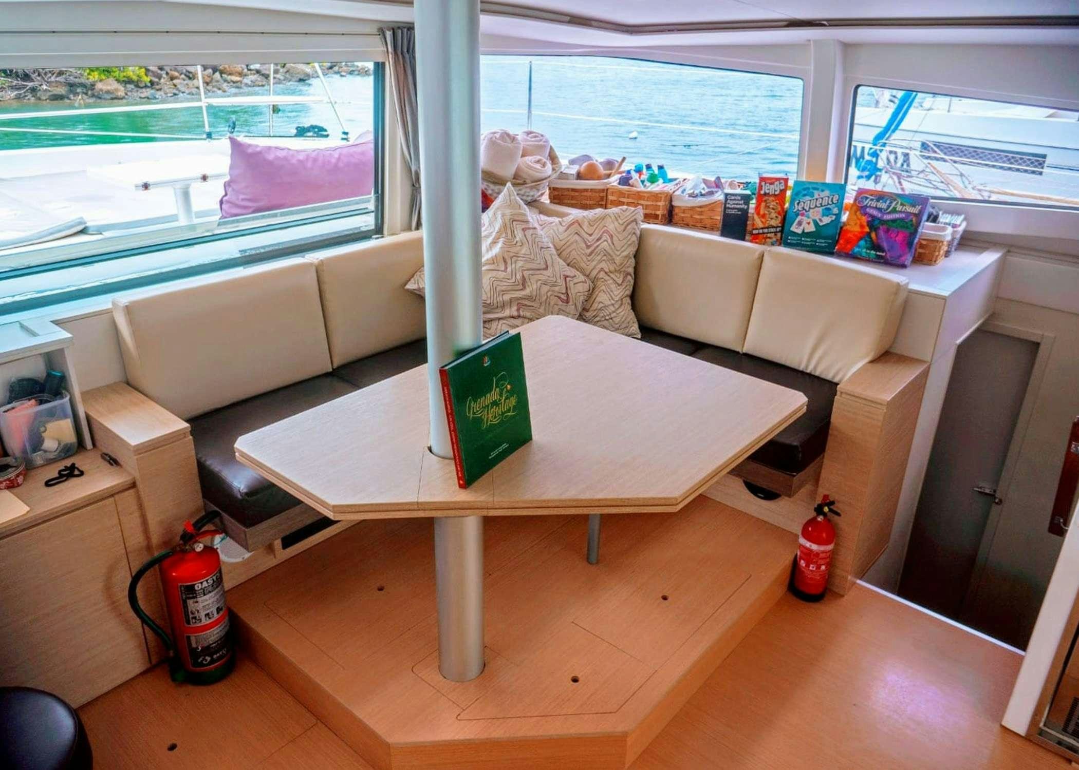 a living room with a table and a window aboard Raiatea Yacht for Charter