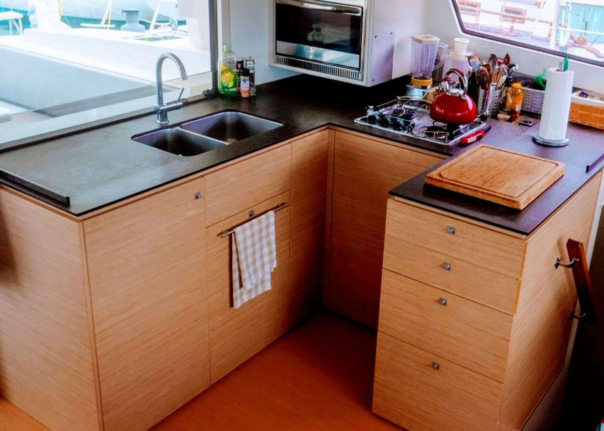 a kitchen with a microwave oven and a sink aboard Raiatea Yacht for Charter