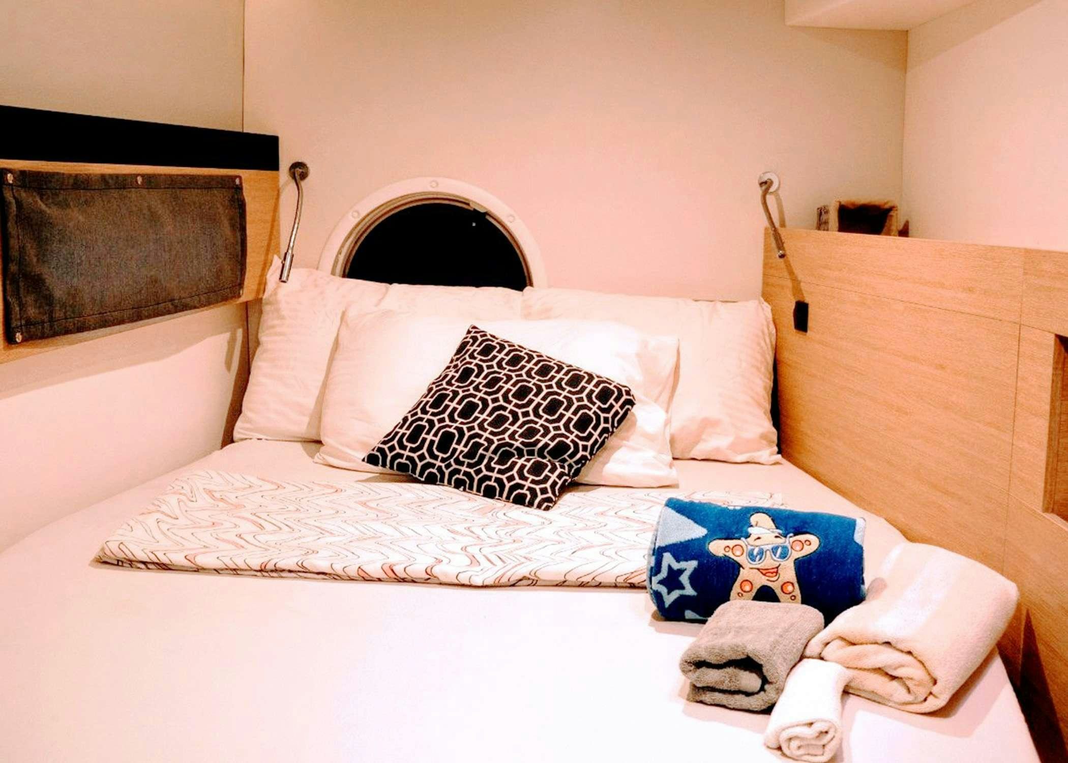 a bed with a white sheet and pillows aboard Raiatea Yacht for Charter