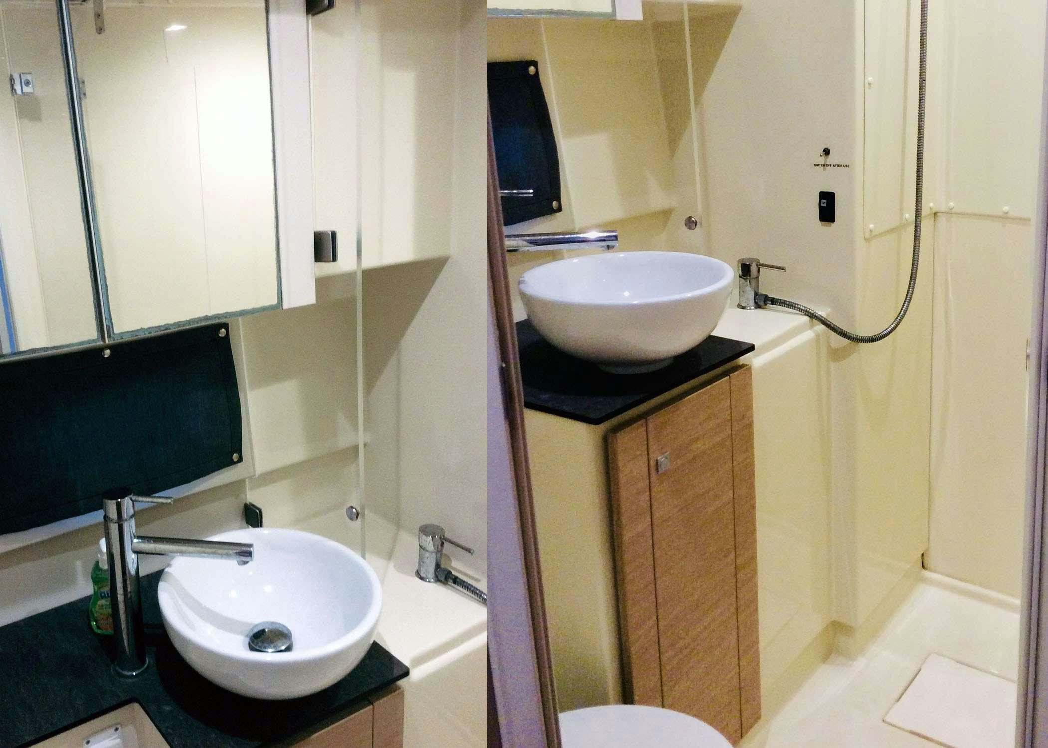 a bathroom with a sink and a tv aboard Raiatea Yacht for Charter