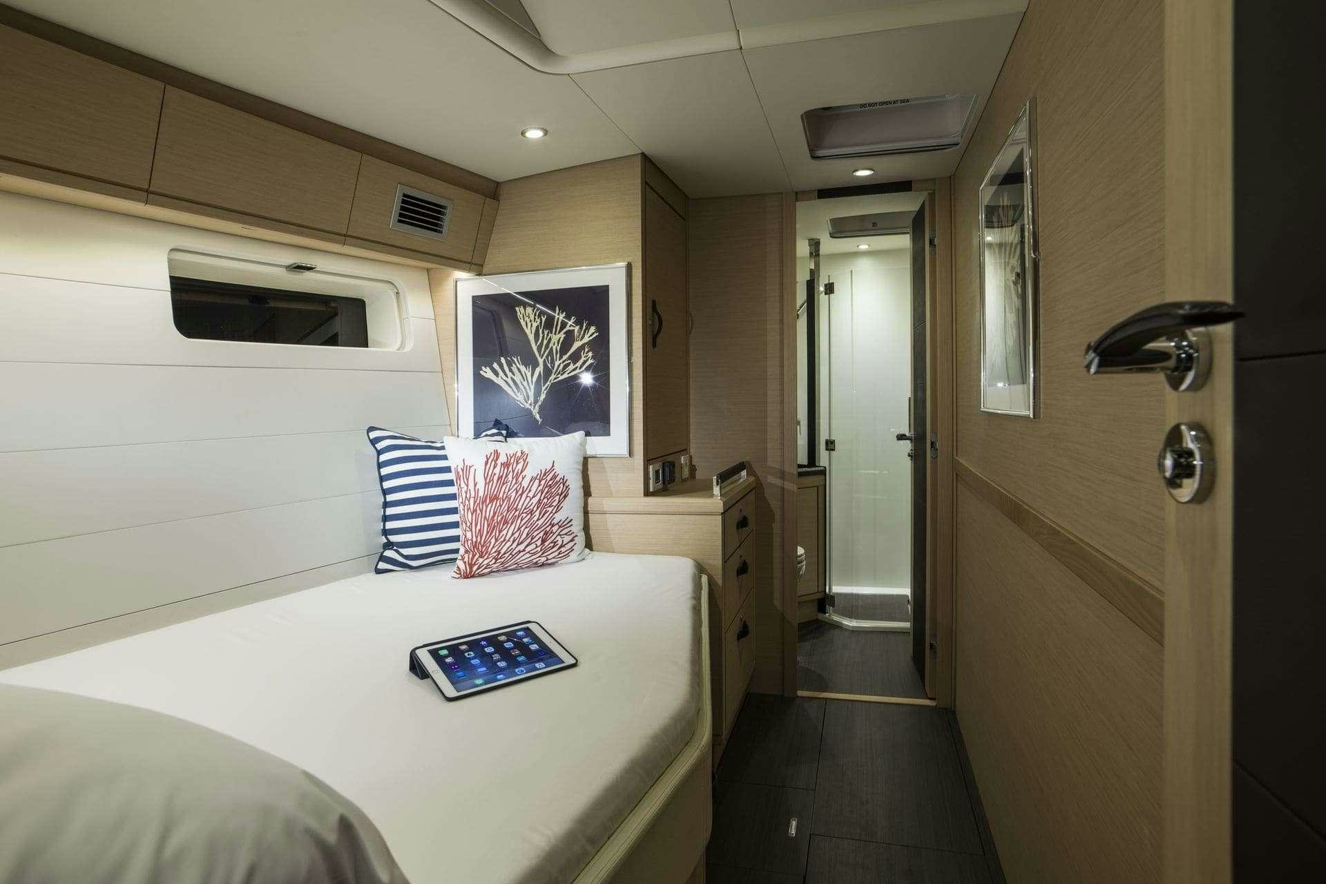 a hotel room with a bed and a phone aboard THEA Yacht for Charter