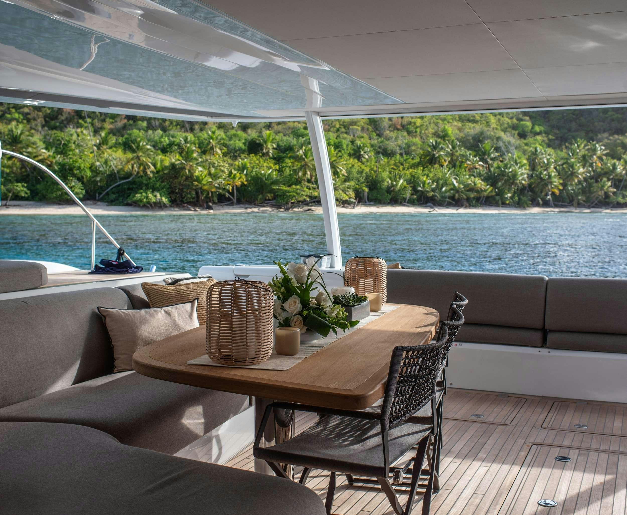 a table and chairs on a deck aboard C’EST LA VIE Yacht for Charter